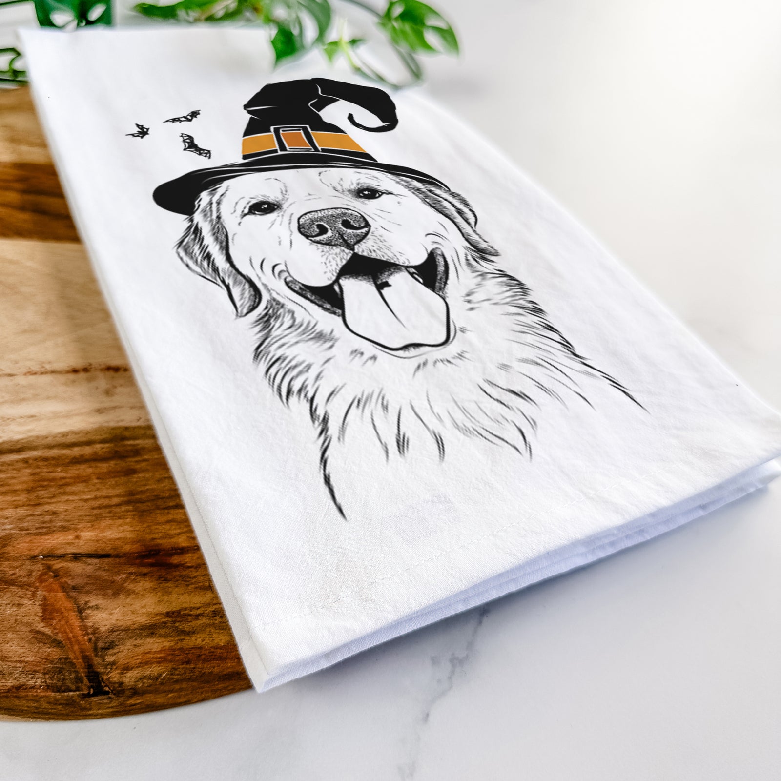 Hand-drawn sketch of Bennett the Golden Retriever wearing a witch hat on a tea towel
