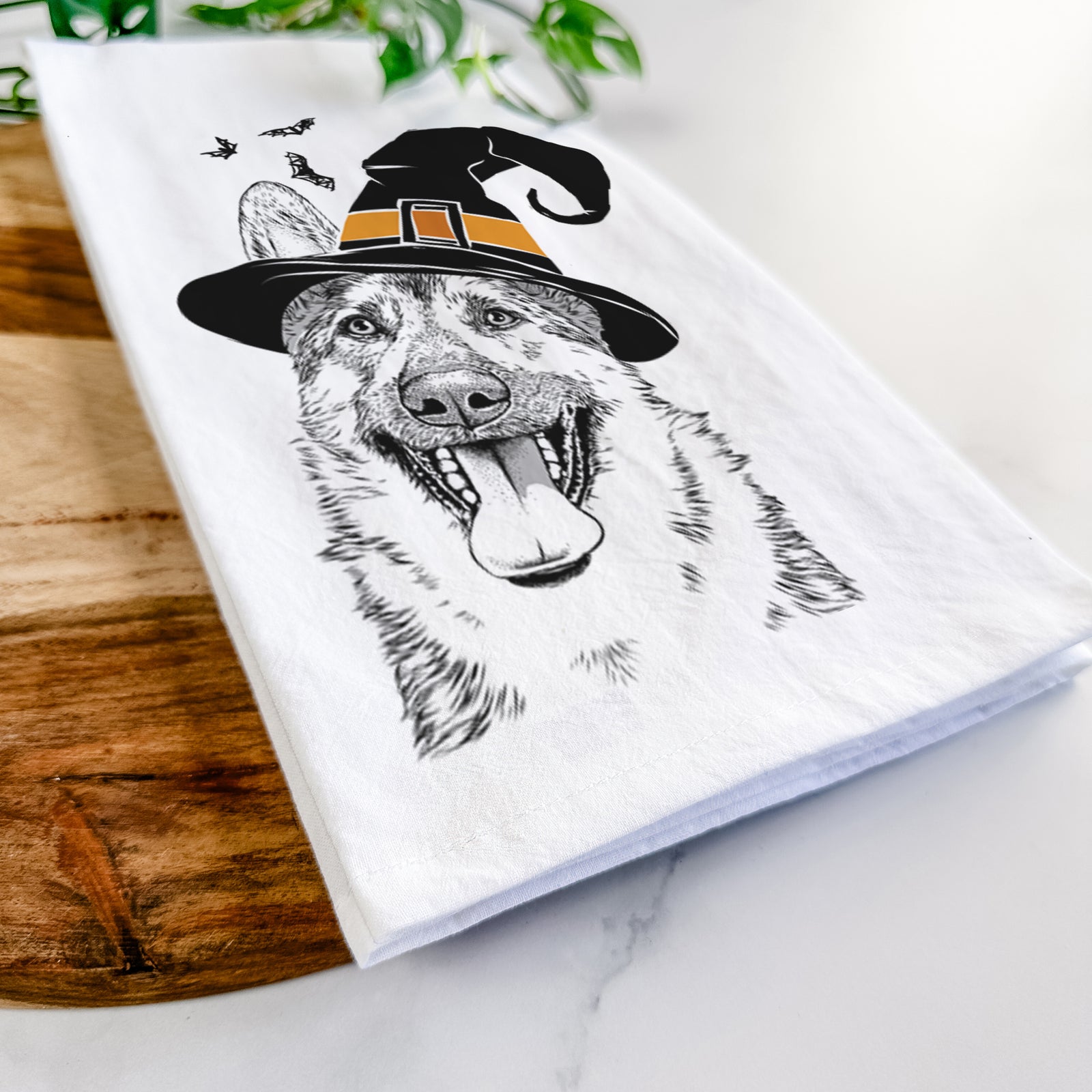 Hand-drawn sketch of Benson the German Shepherd wearing a witch hat on a tea towel