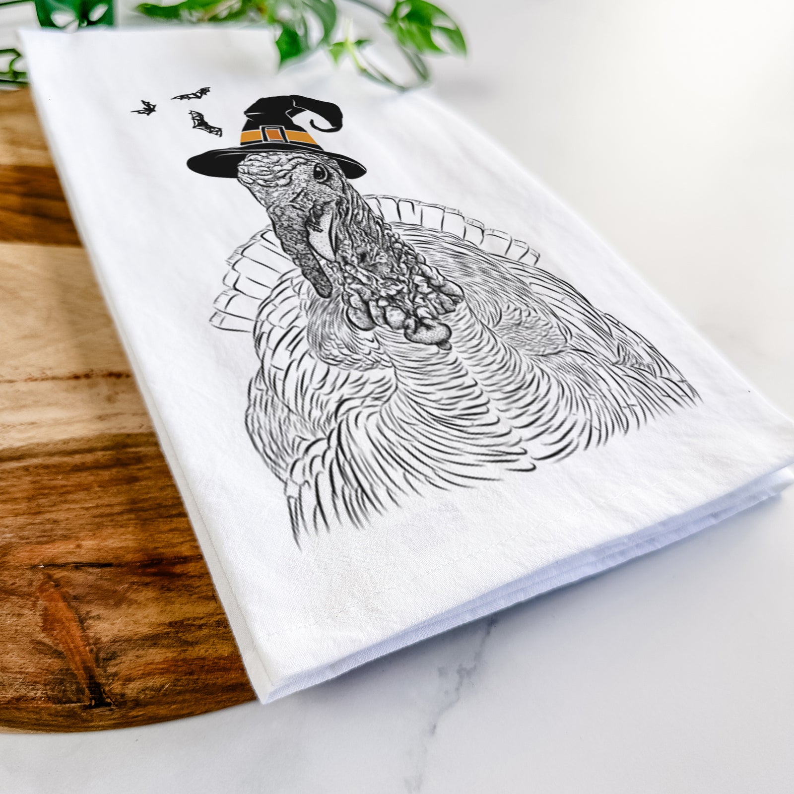Hand-drawn sketch of Brady the Turkey wearing a witch hat on a tea towel