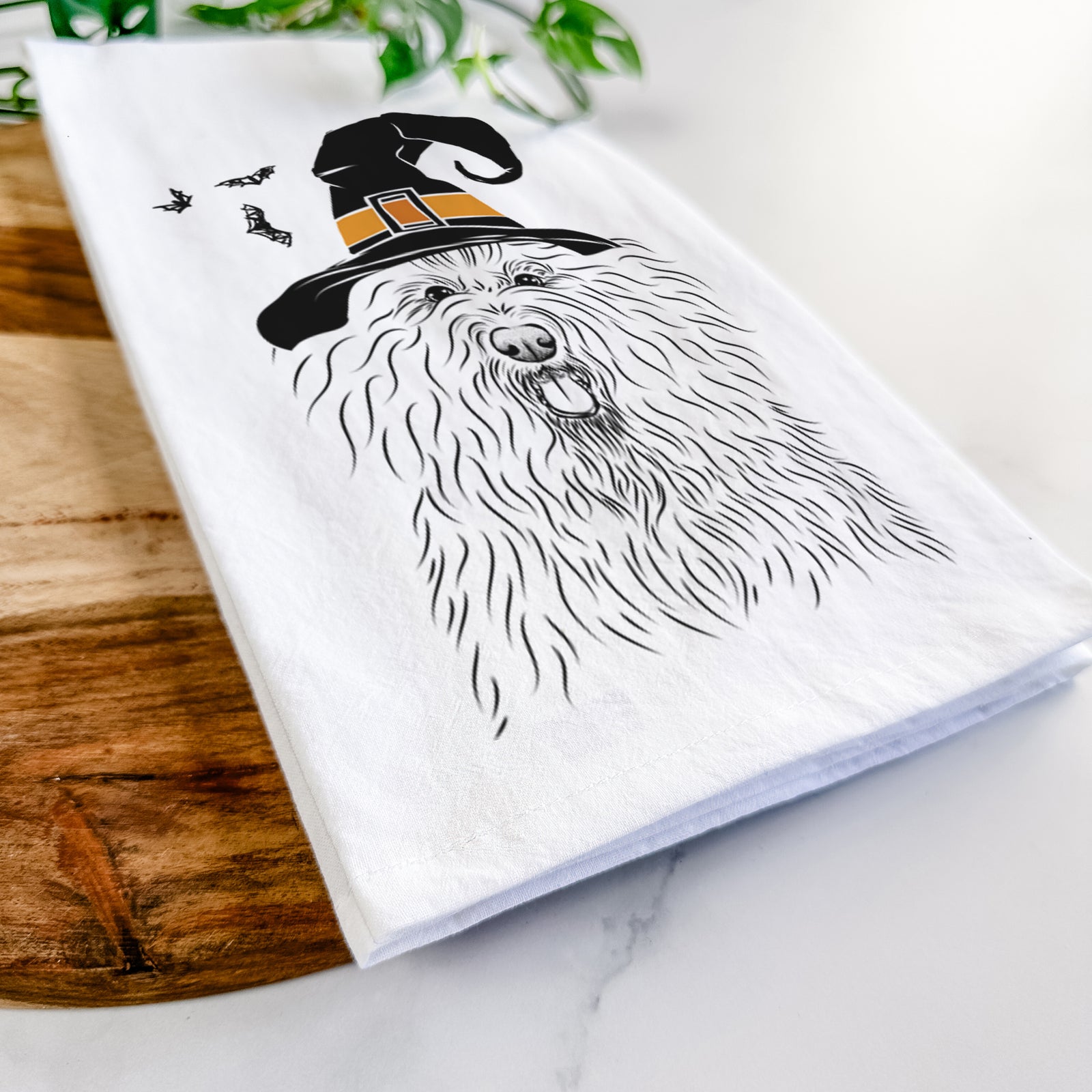 Hand-drawn sketch of Brody the Old English Sheepdog wearing a witch hat on a tea towel