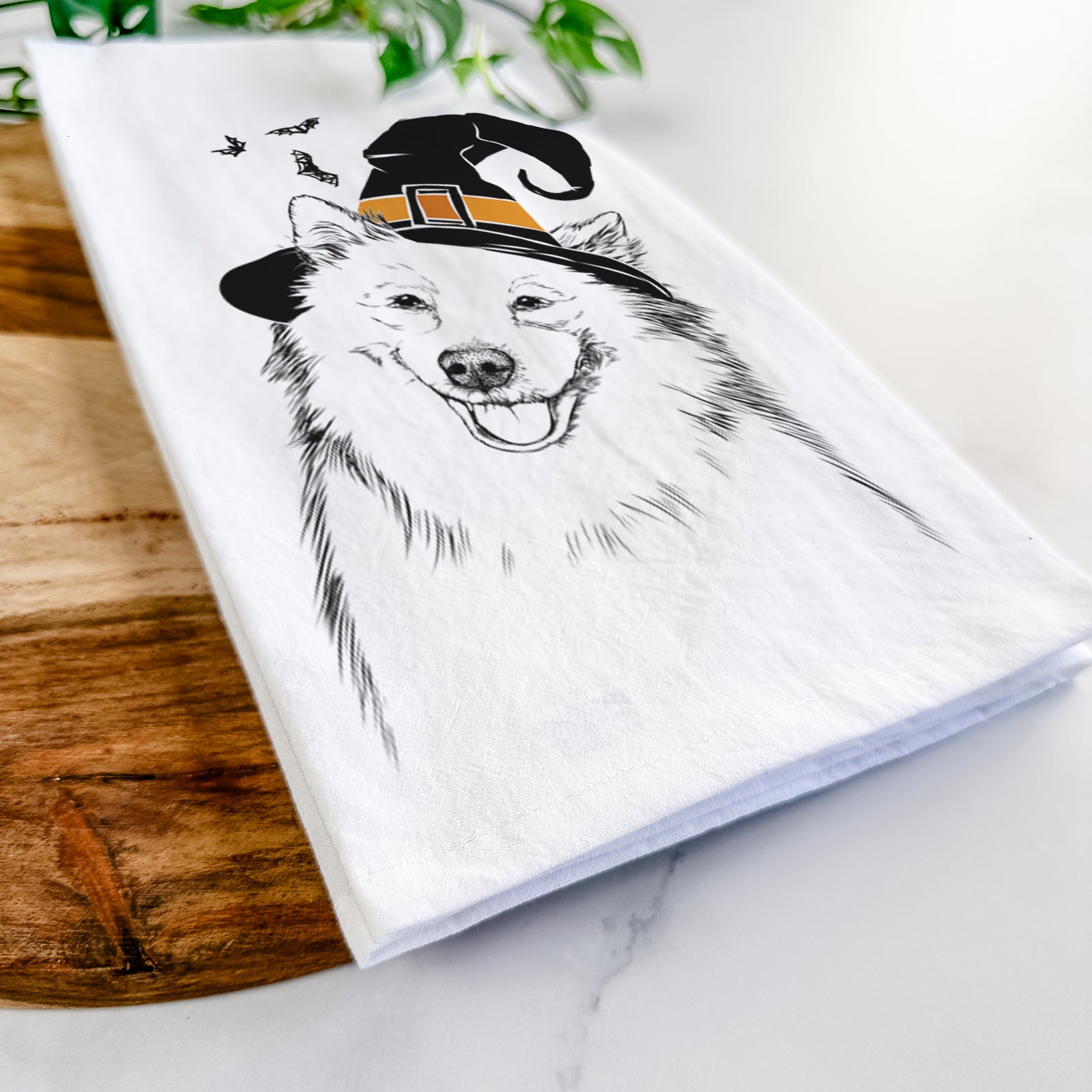 Hand-drawn sketch of Caico the Samoyed wearing a witch hat on a tea towel