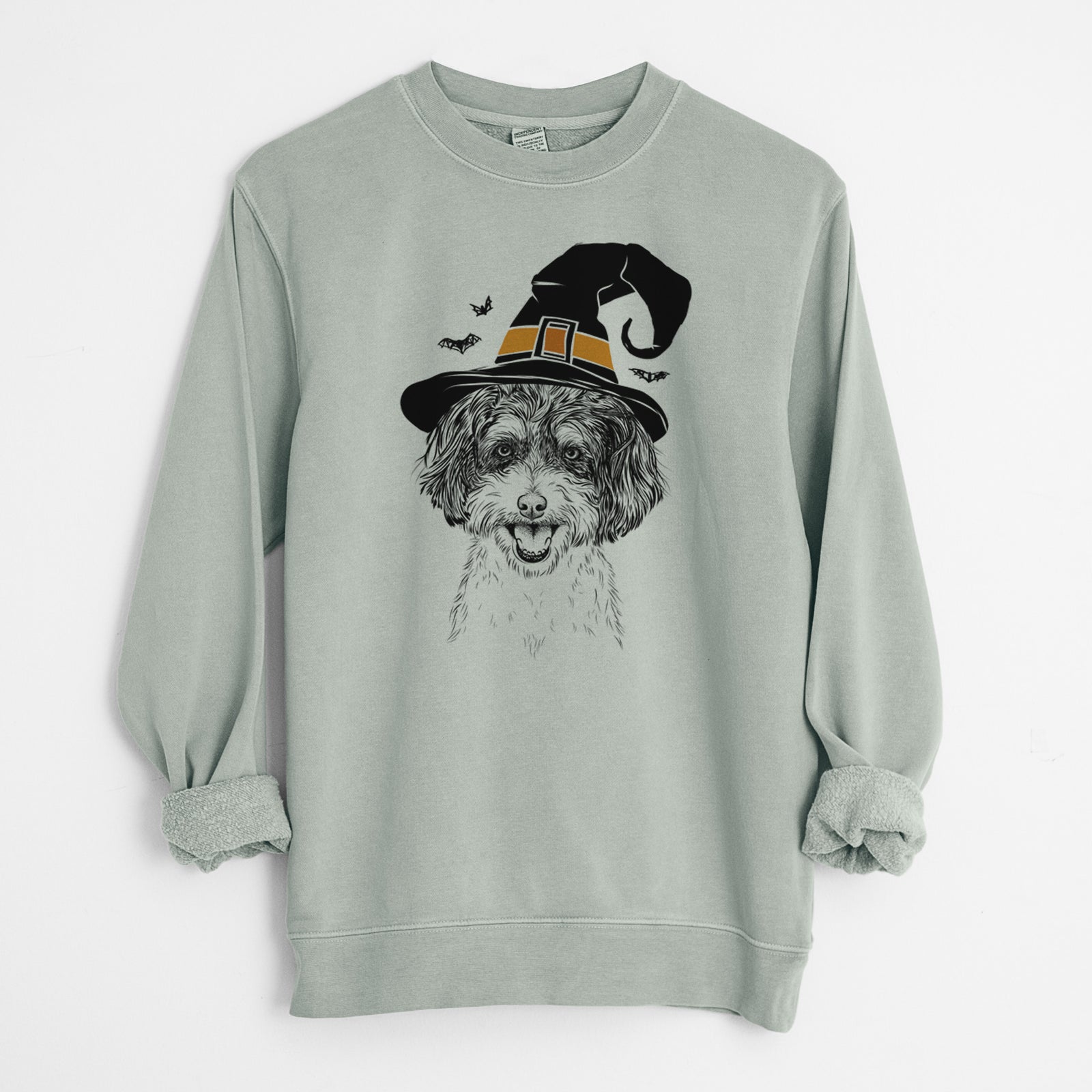 Hand-drawn sketch of Carlos the Cavapoo wearing a witch hat on a Sage Unisex pigment dyed crew sweatshirt
