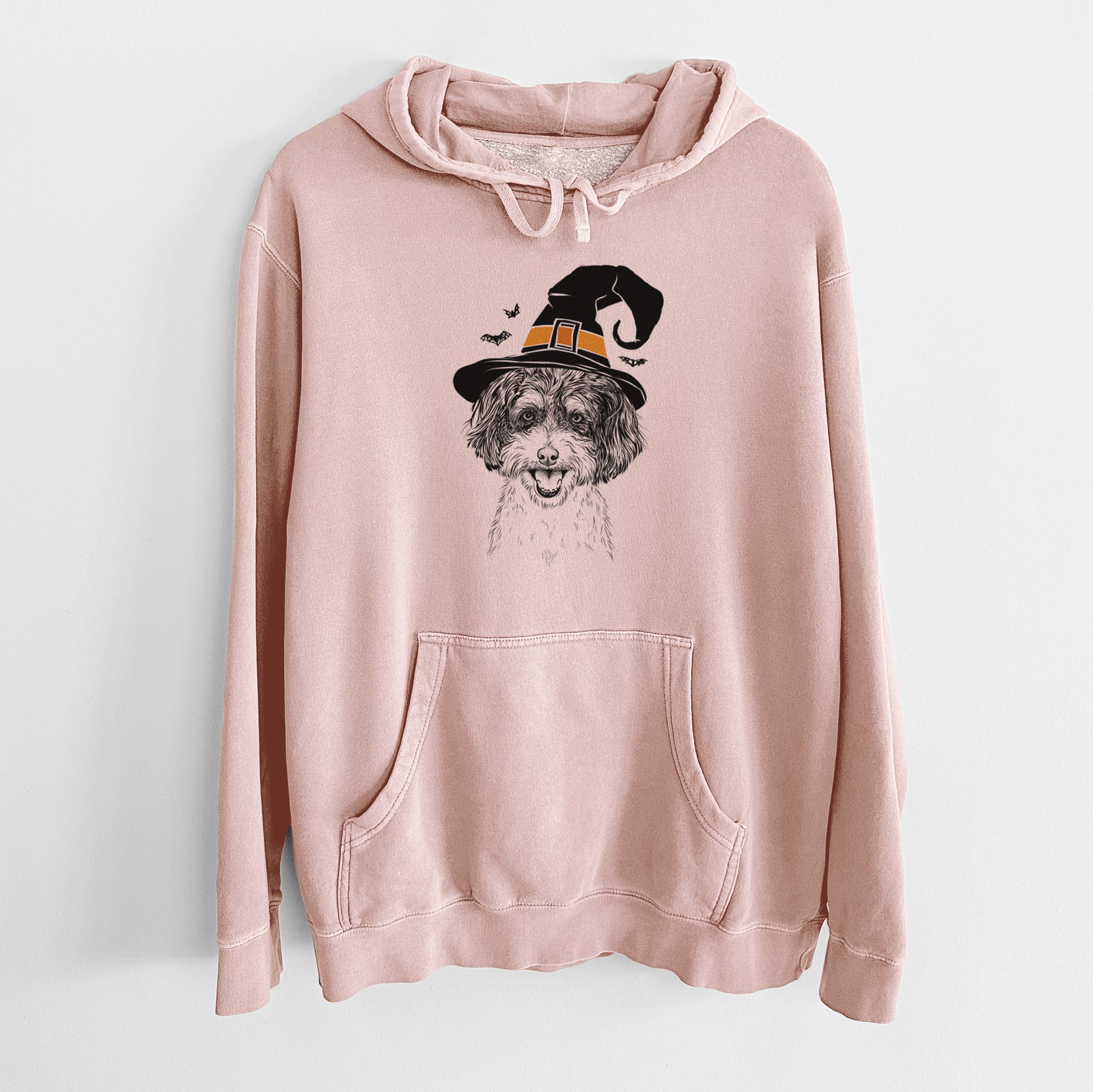 Hand-drawn sketch of Carlos the Cavapoo wearing a witch hat on a Dusty Pink Unisex pigment dyed hoodie