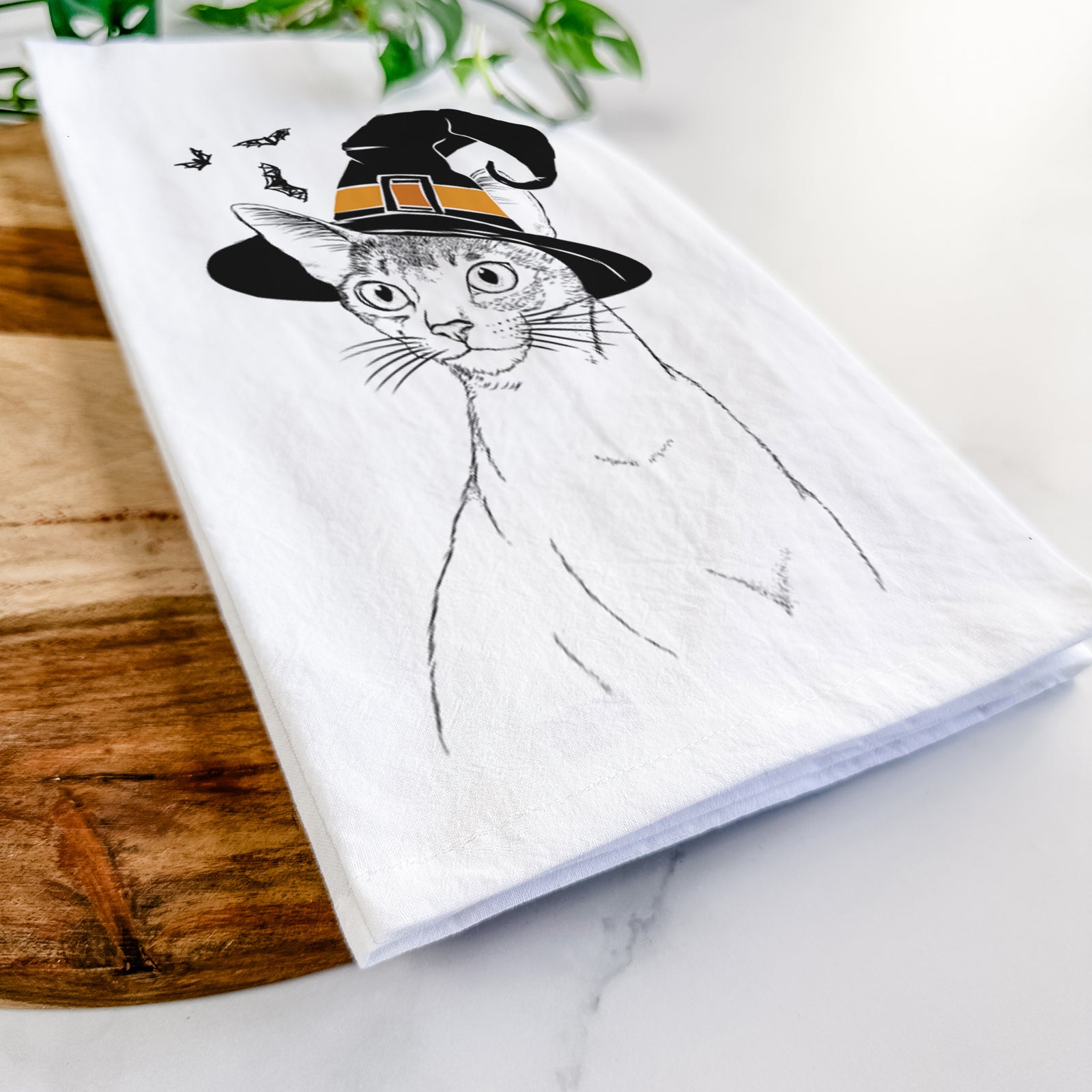 Hand-drawn sketch of Cedric the Abyssinian Cat wearing a witch hat on a tea towel