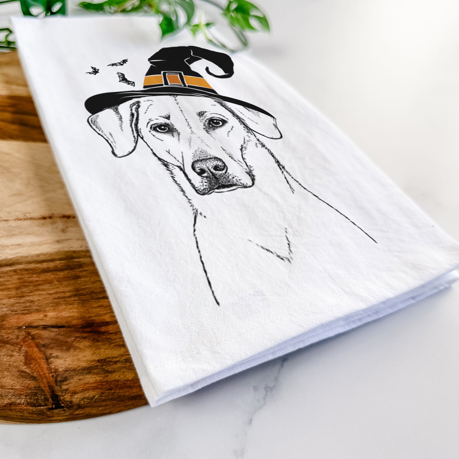 Hand-drawn sketch of Charlie Girl the Yellow Lab wearing a witch hat on a tea towel