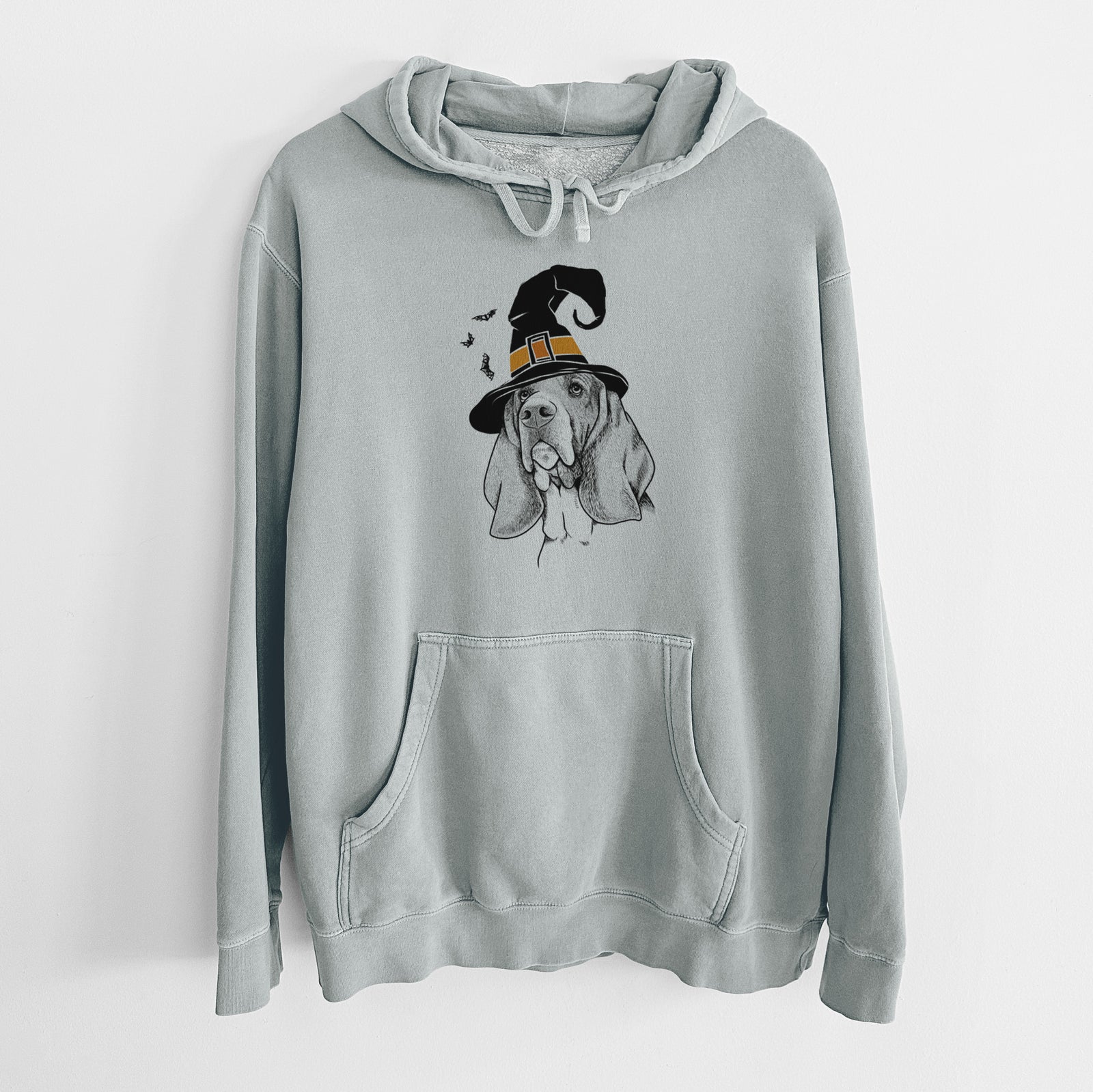 Hand-drawn sketch of Cooper the Basset Hound wearing a witch hat on a Sage Unisex pigment dyed hoodie