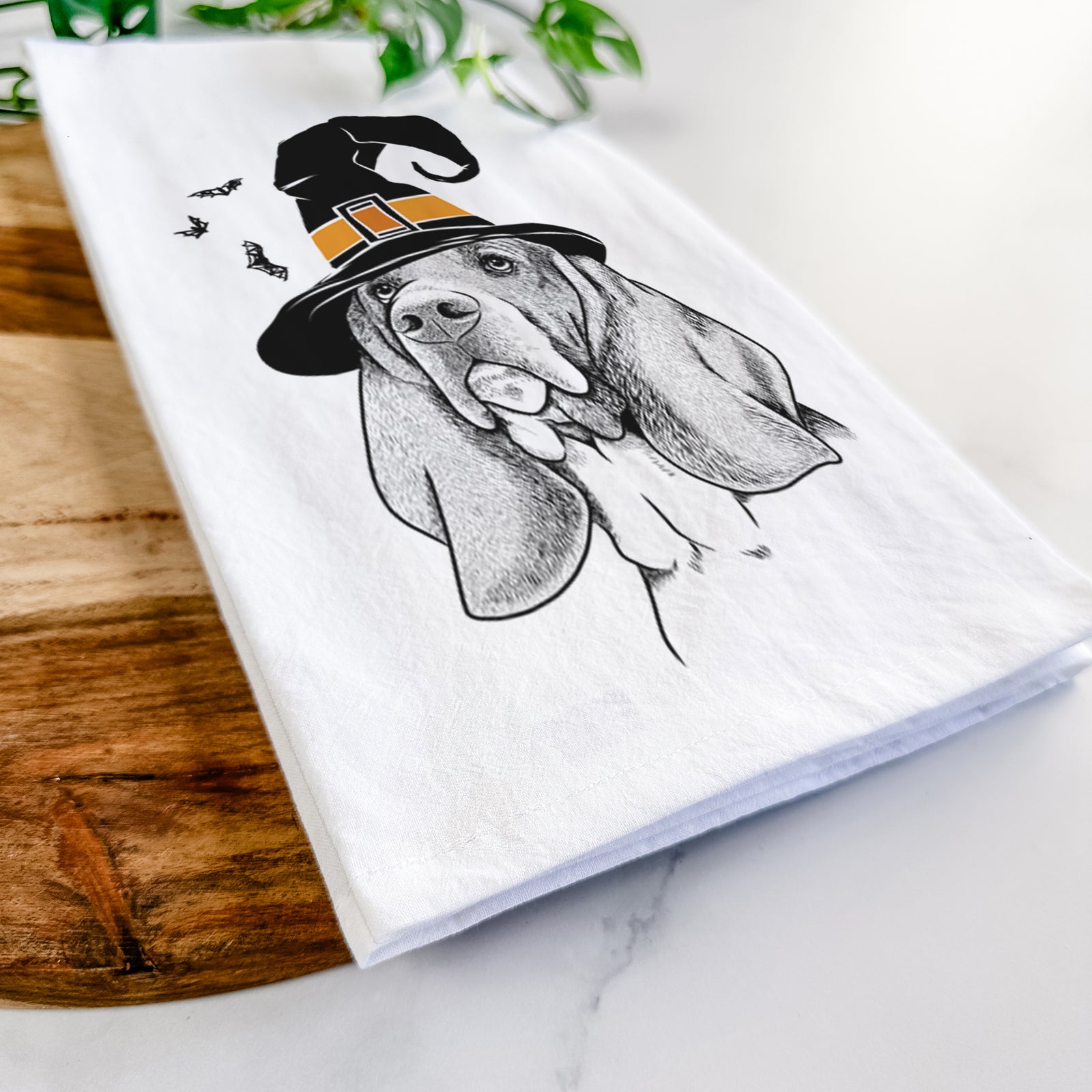 Hand-drawn sketch of Cooper the Basset Hound wearing a witch hat on a tea towel
