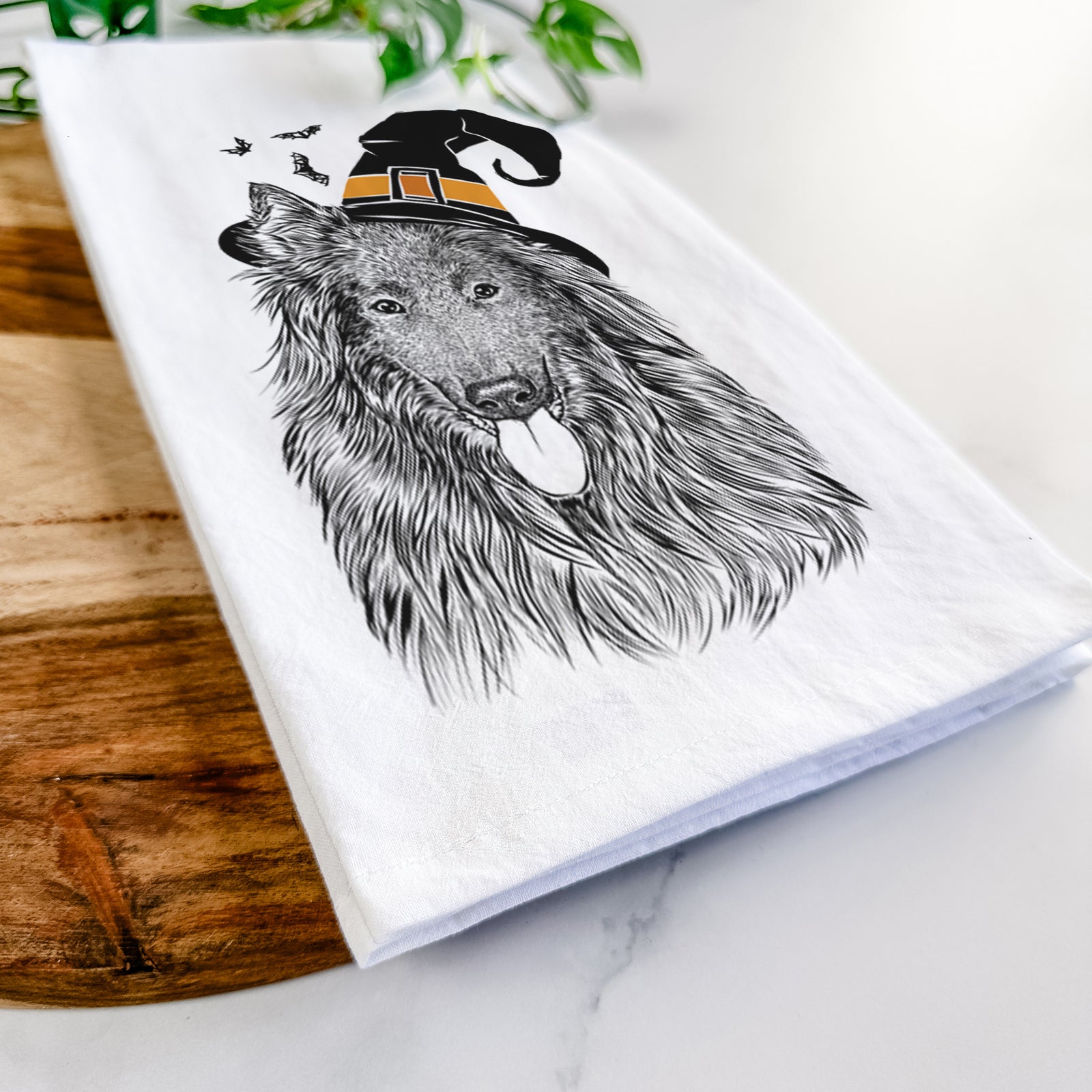 Hand-drawn sketch of Daan the Belgian Shepherd wearing a witch hat on a tea towel