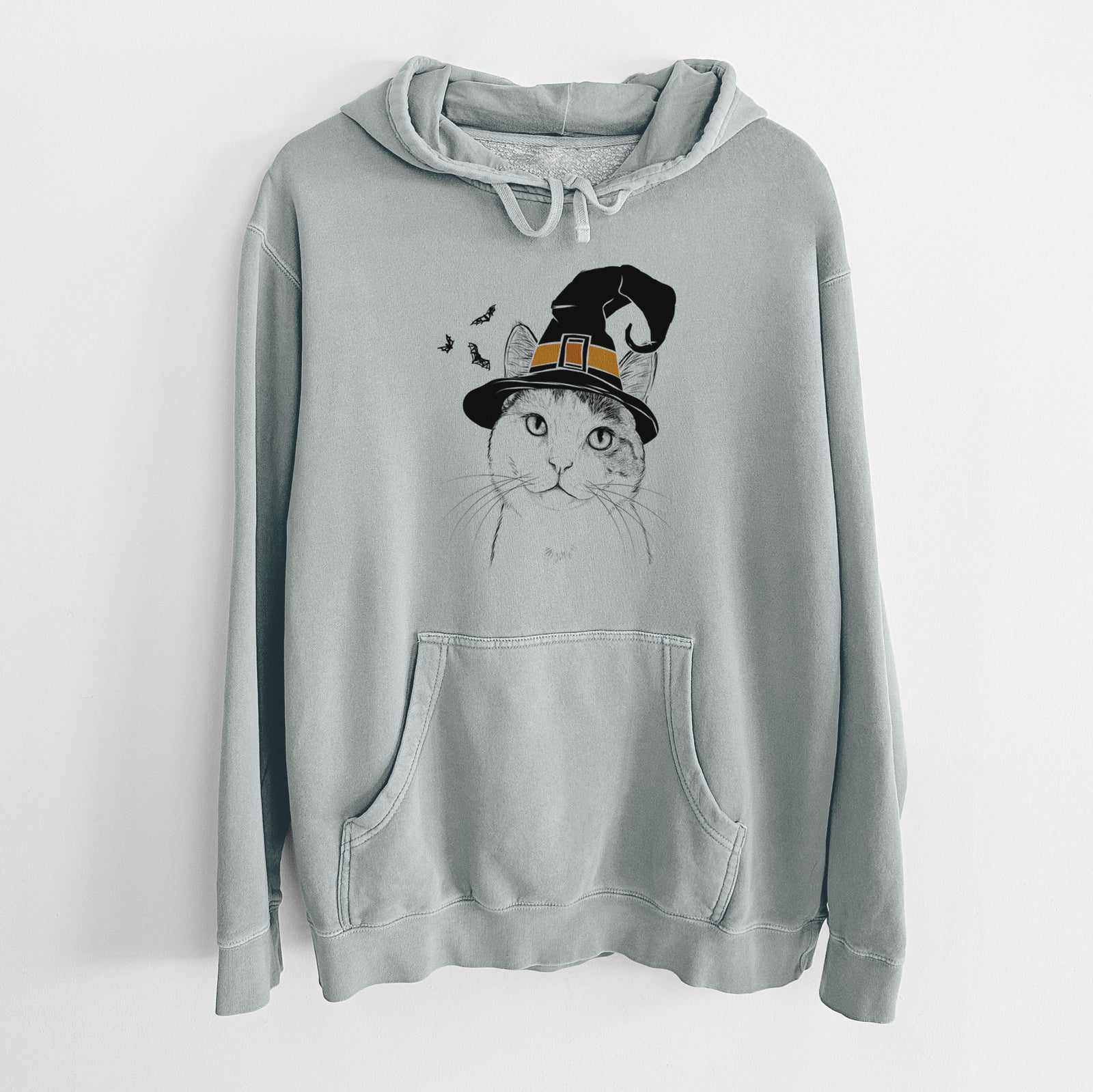 Hand-drawn sketch of Denver the Calico Cat wearing a witch hat on a Sage Unisex pigment dyed hoodie