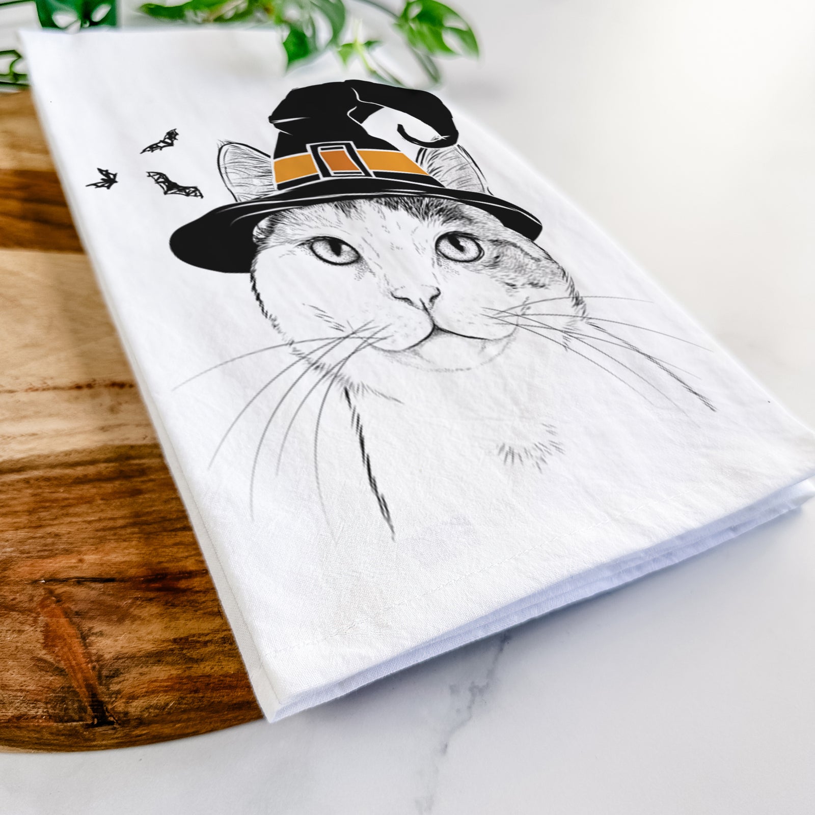 Hand-drawn sketch of Denver the Calico Cat wearing a witch hat on a tea towel
