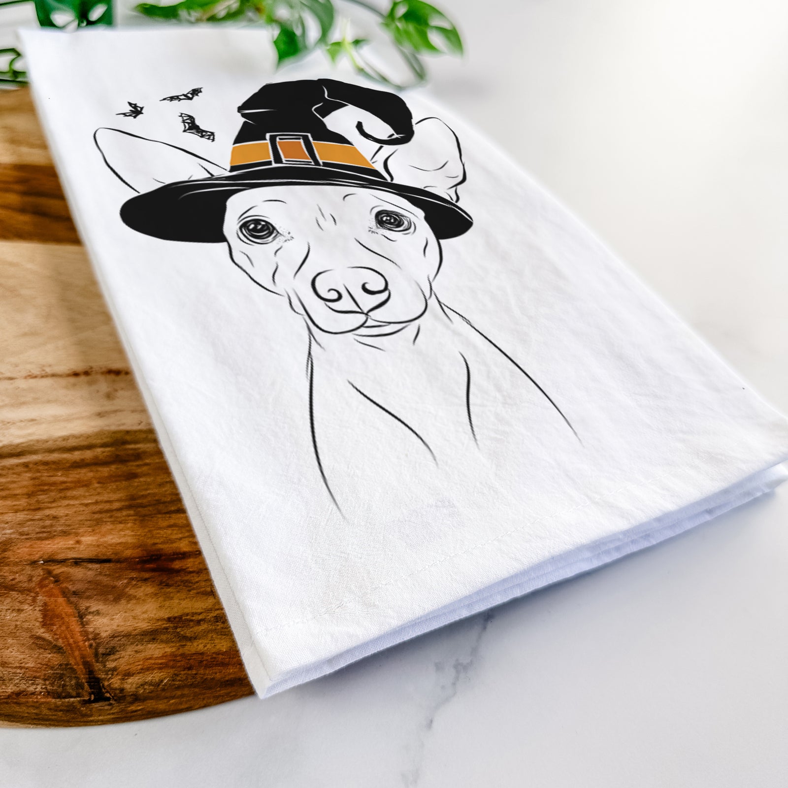 Hand-drawn sketch of Desi the American Hairless Terrier wearing a witch hat on a tea towel