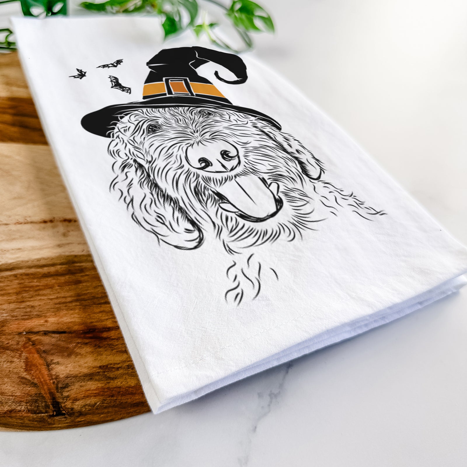 Hand-drawn sketch of Dixie the Doodle wearing a witch hat on a tea towel