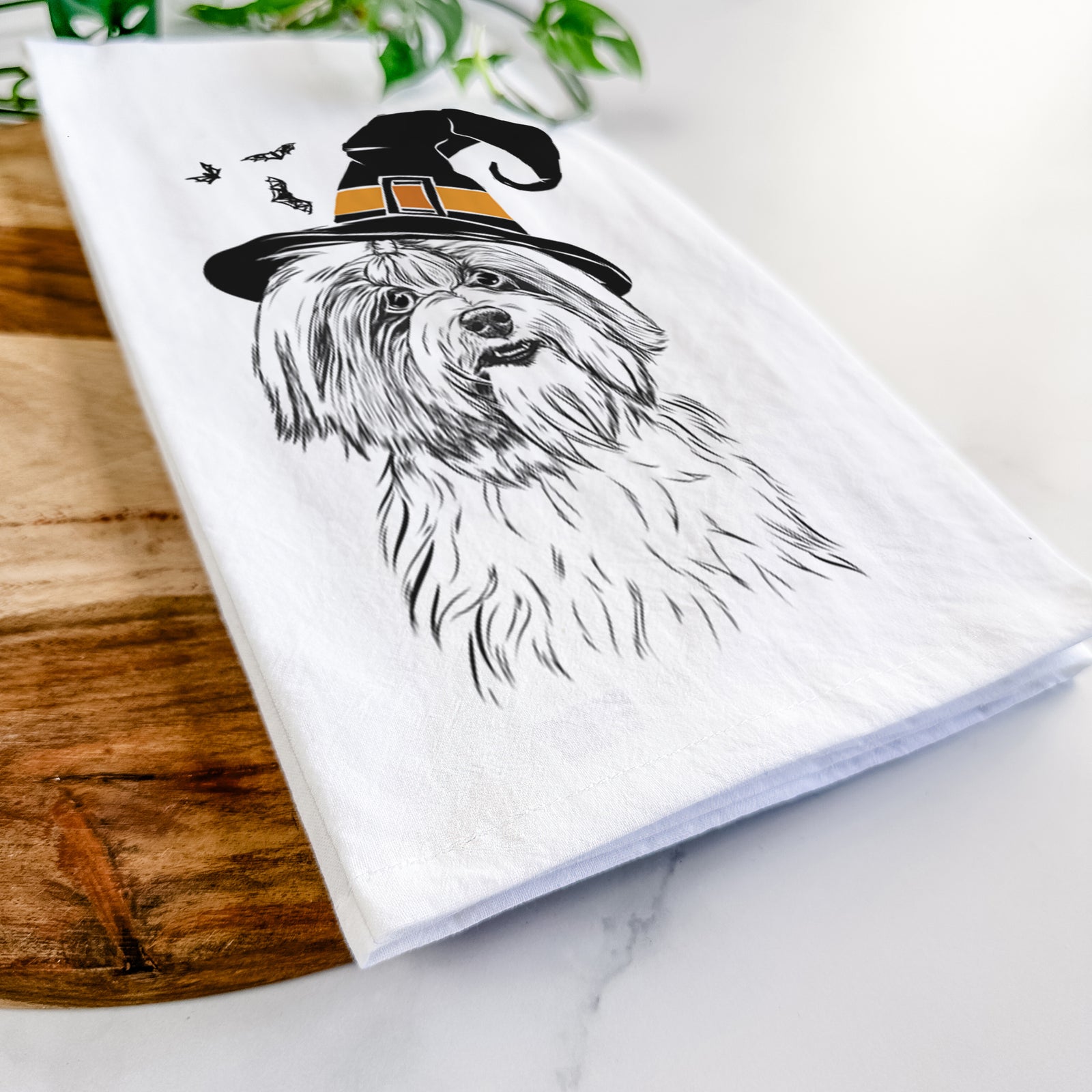 Hand-drawn sketch of Dooley the Havanese wearing a witch hat on a tea towel