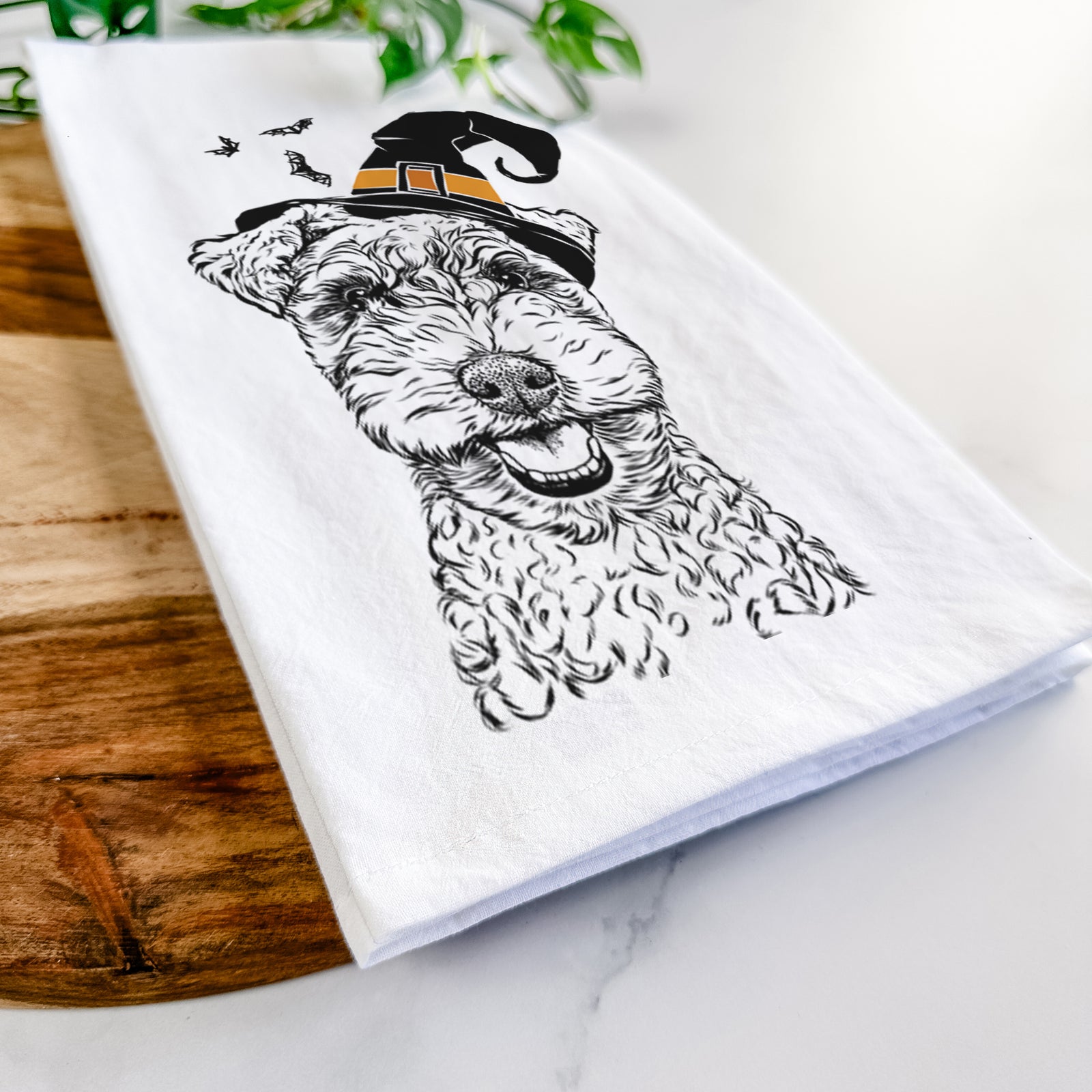 Hand-drawn sketch of Fintan the Irish Troodle wearing a witch hat on a tea towel