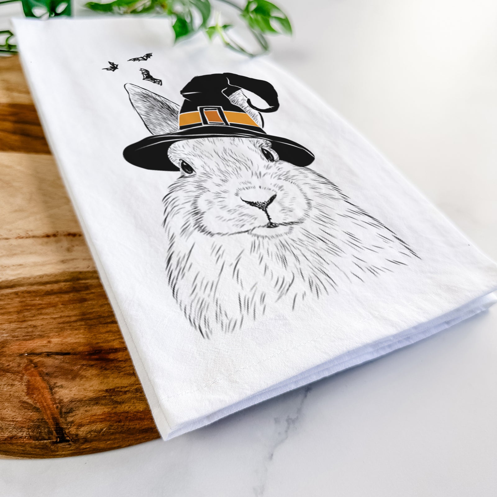 Hand-drawn sketch of Flower the Rex Rabbit wearing a witch hat on a tea towel