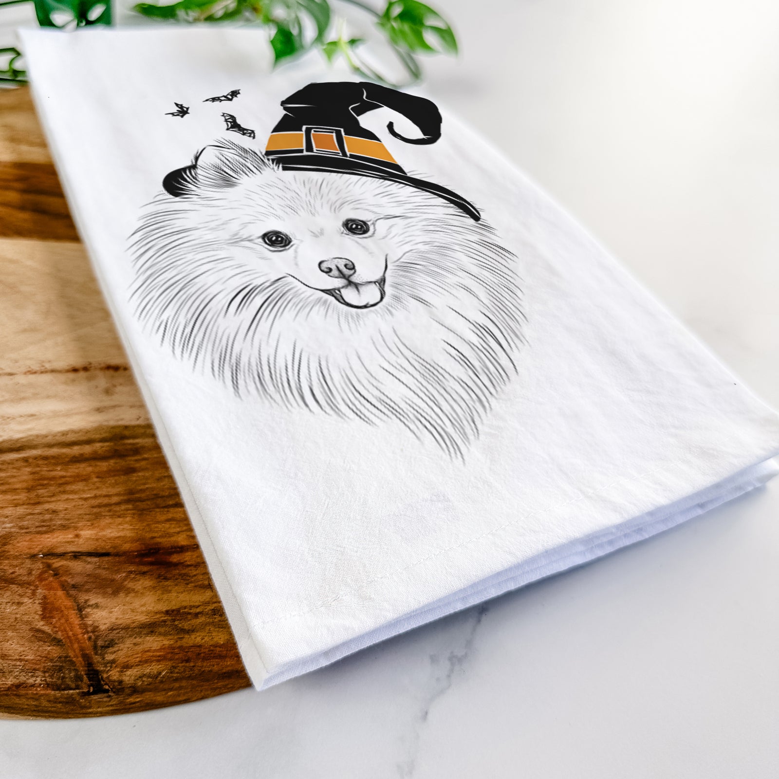 Hand-drawn sketch of GiGi the Pomeranian wearing a witch hat on a tea towel
