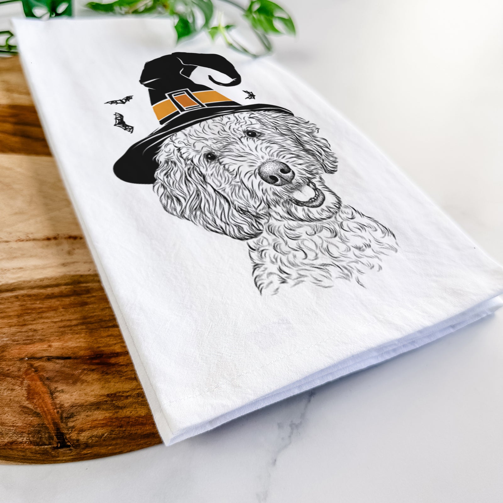 Hand-drawn sketch of Gizmo the Goldendoodle wearing a witch hat on a tea towel