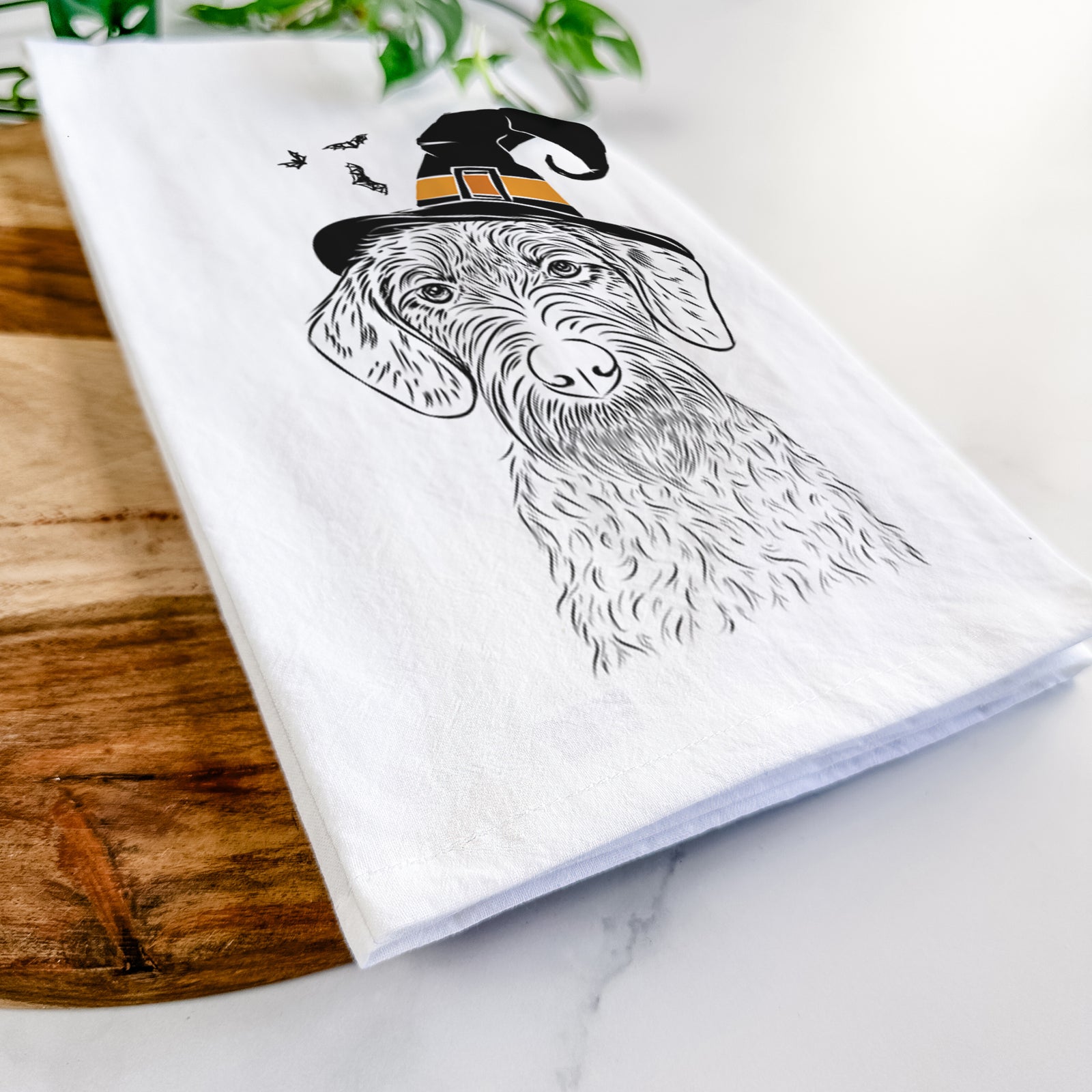 Hand-drawn sketch of Gus the German Wirehaired Pointer wearing a witch hat on a tea towel