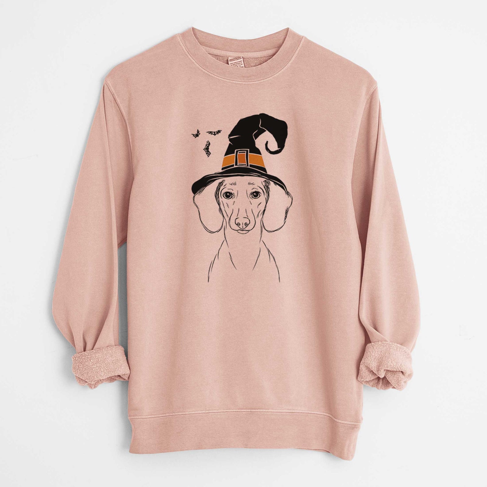 Hand-drawn sketch of Hans the Dachshund wearing a witch hat on a Dusty Pink Unisex pigment dyed crew sweatshirt