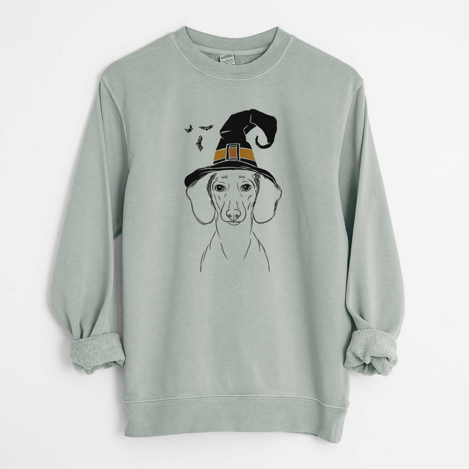 Hand-drawn sketch of Hans the Dachshund wearing a witch hat on a Sage Unisex pigment dyed crew sweatshirt