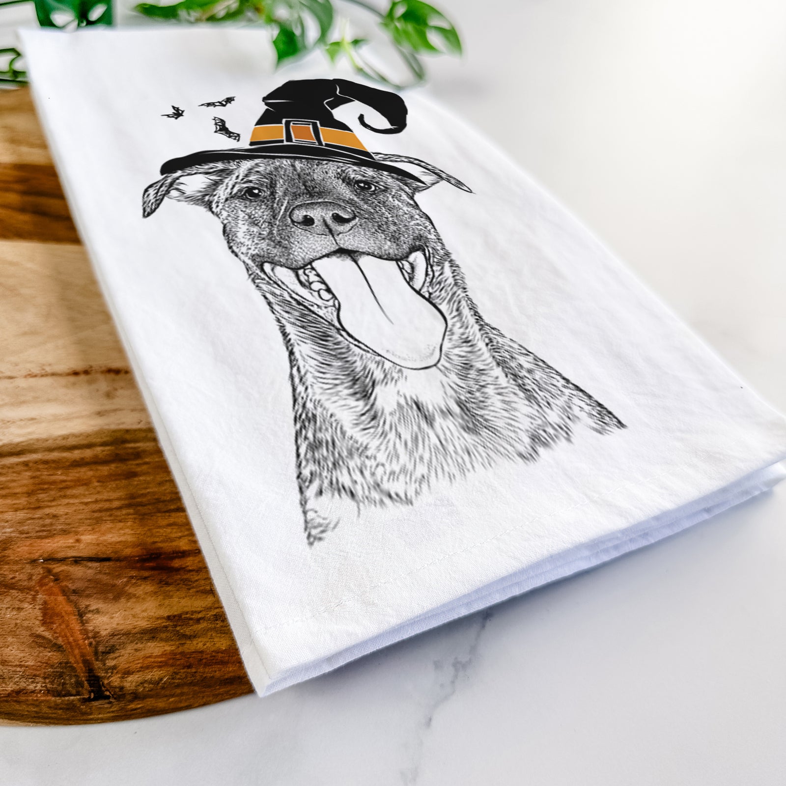 Hand-drawn sketch of Harley the Pitbull Mix wearing a witch hat on a tea towel