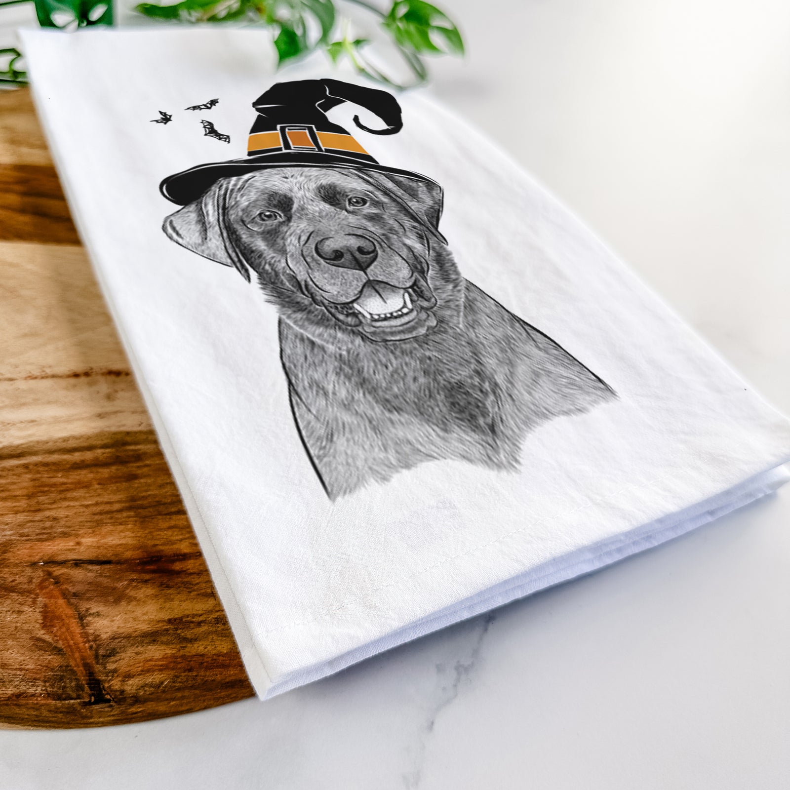 Hand-drawn sketch of Heath the Black Lab wearing a witch hat on a tea towel
