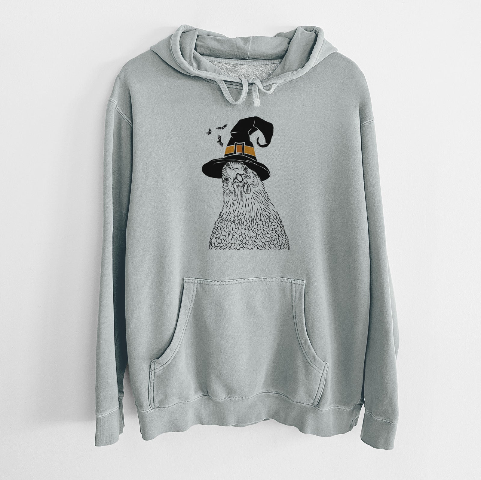 Hand-drawn sketch of Henrietta the Chicken wearing a witch hat on a Sage Unisex pigment dyed hoodie