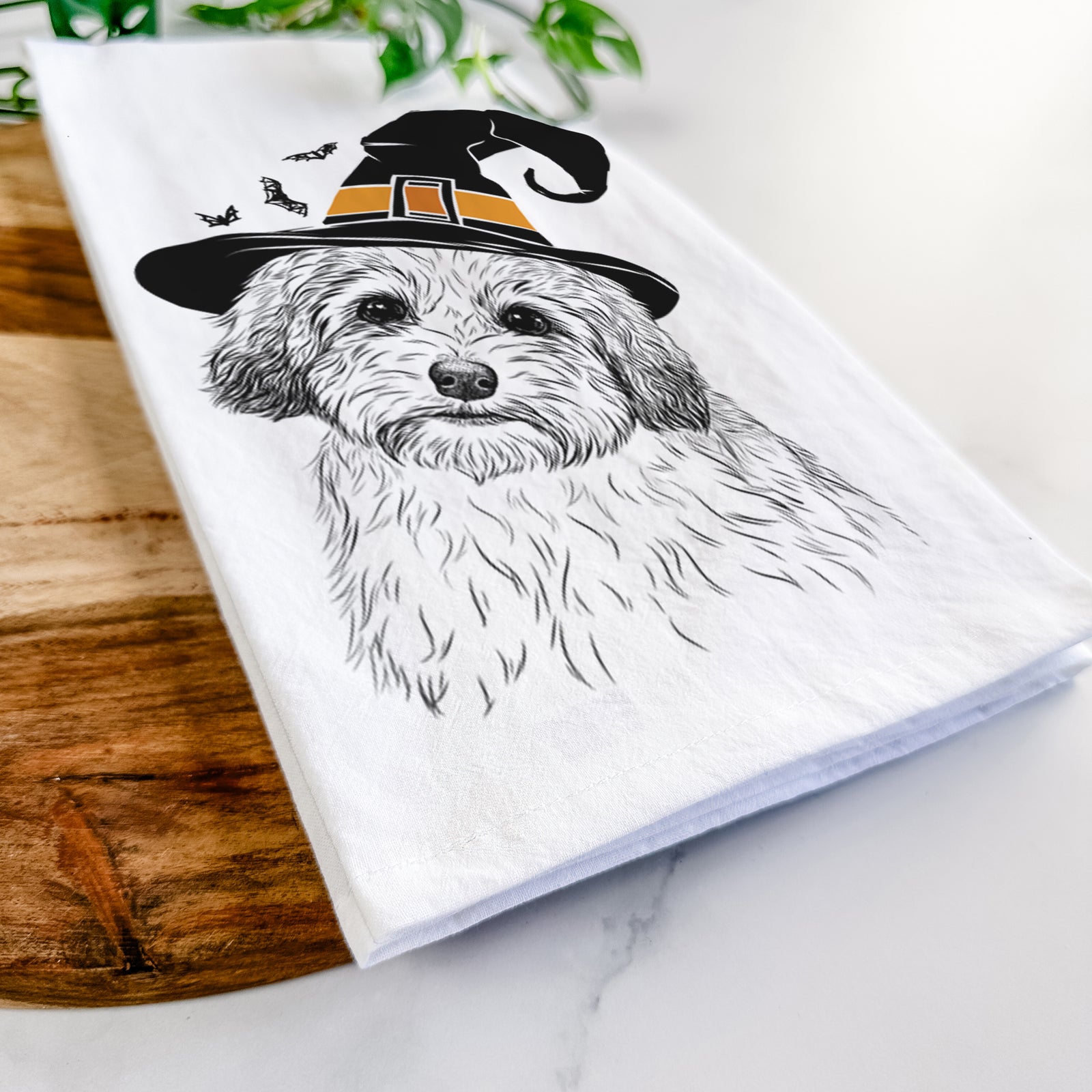 Hand-drawn sketch of Henry the Havanese wearing a witch hat on a tea towel
