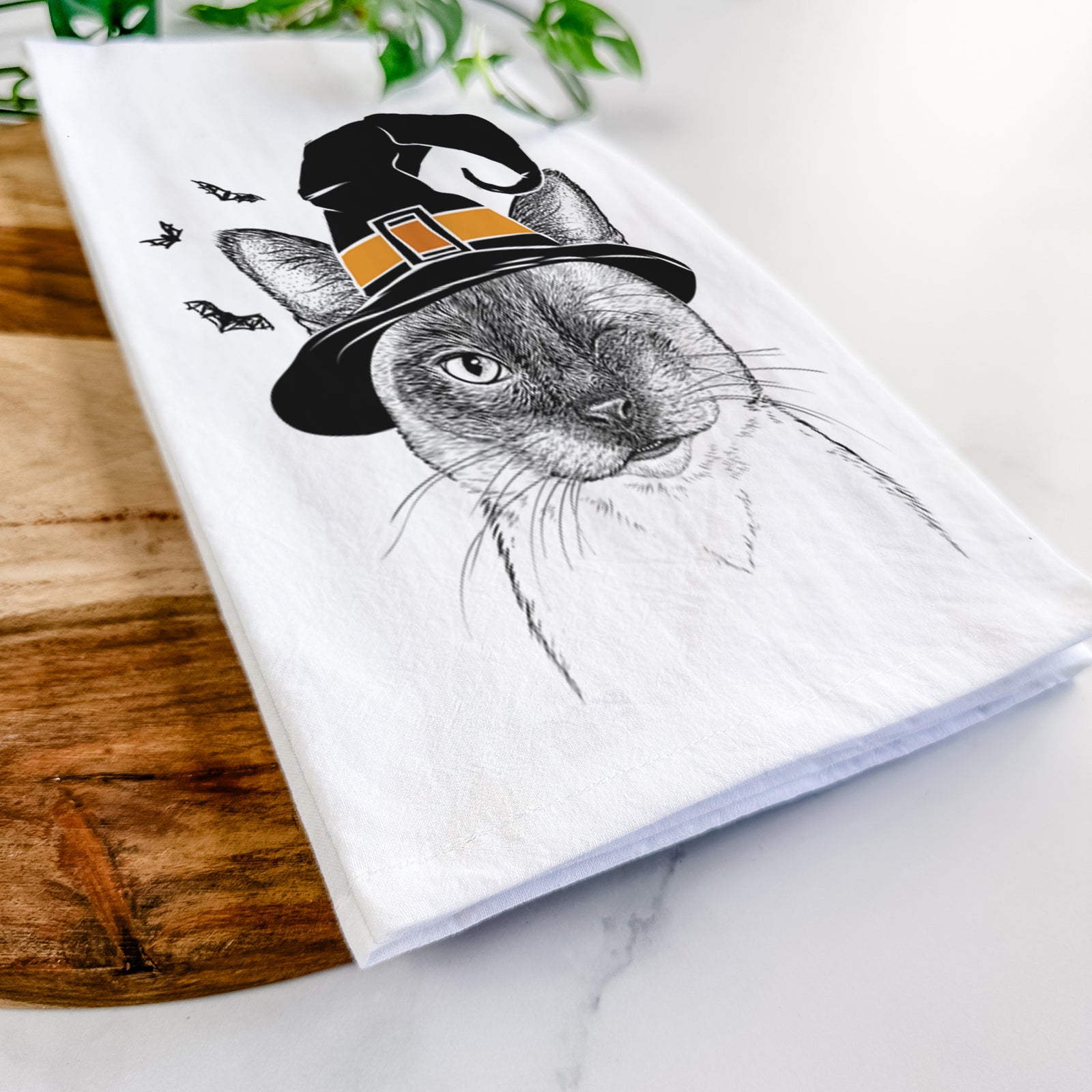 Hand-drawn sketch of Hoggle the Siamese Cat wearing a witch hat on a tea towel