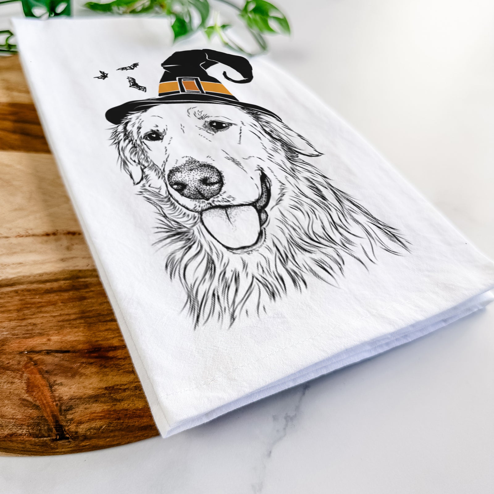 Hand-drawn sketch of Hopper the Golden Retriever wearing a witch hat on a tea towel