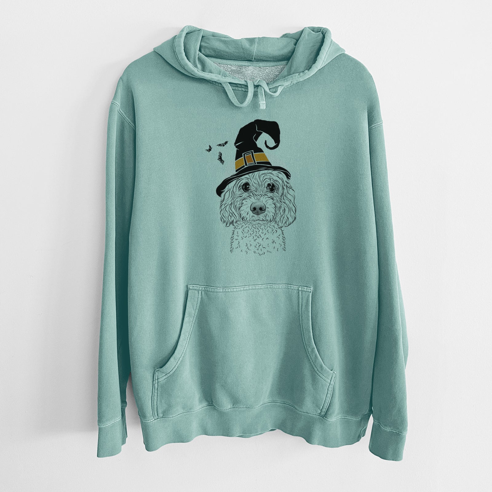 Hand-drawn sketch of Izzie the Cavachon wearing a witch hat on a Mint Unisex pigment dyed hoodie