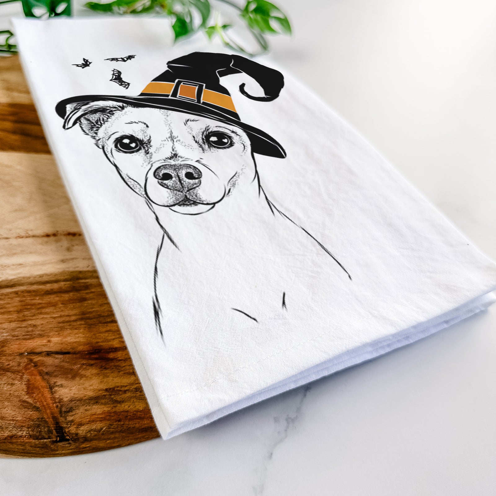 Hand-drawn sketch of Izzy the Chiweenie wearing a witch hat on a tea towel