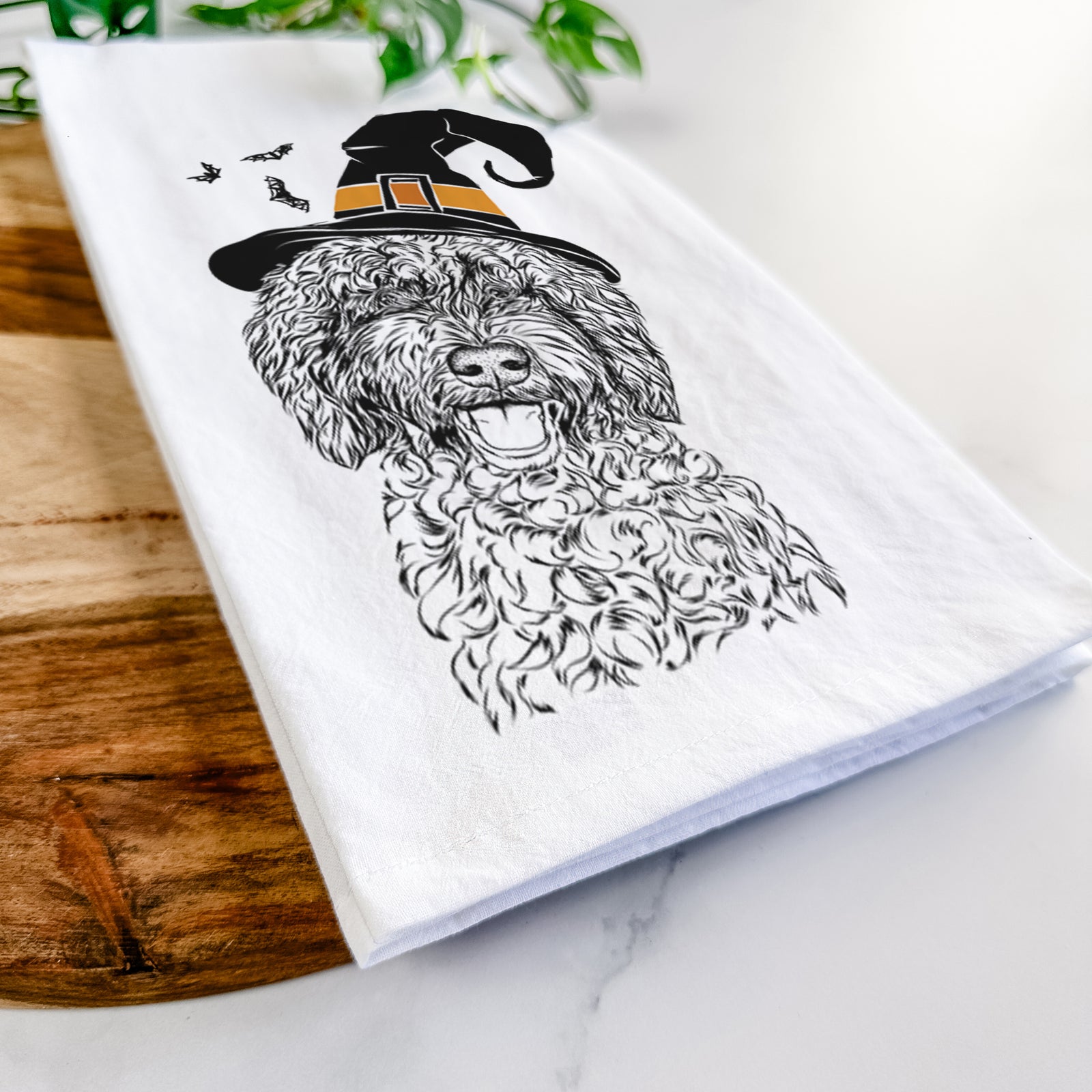 Hand-drawn sketch of Jack the Chocolate Labradoodle wearing a witch hat on a tea towel