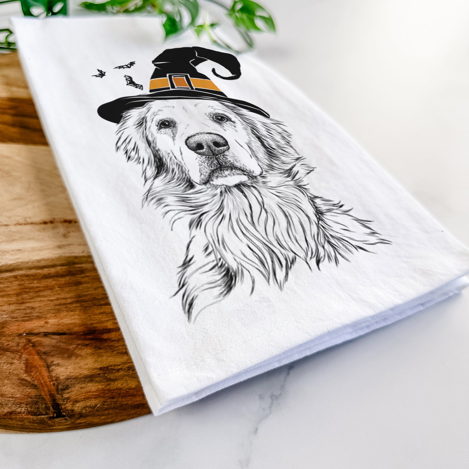 Hand-drawn sketch of Jake aroni the Golden Retriever wearing a witch hat on a tea towel
