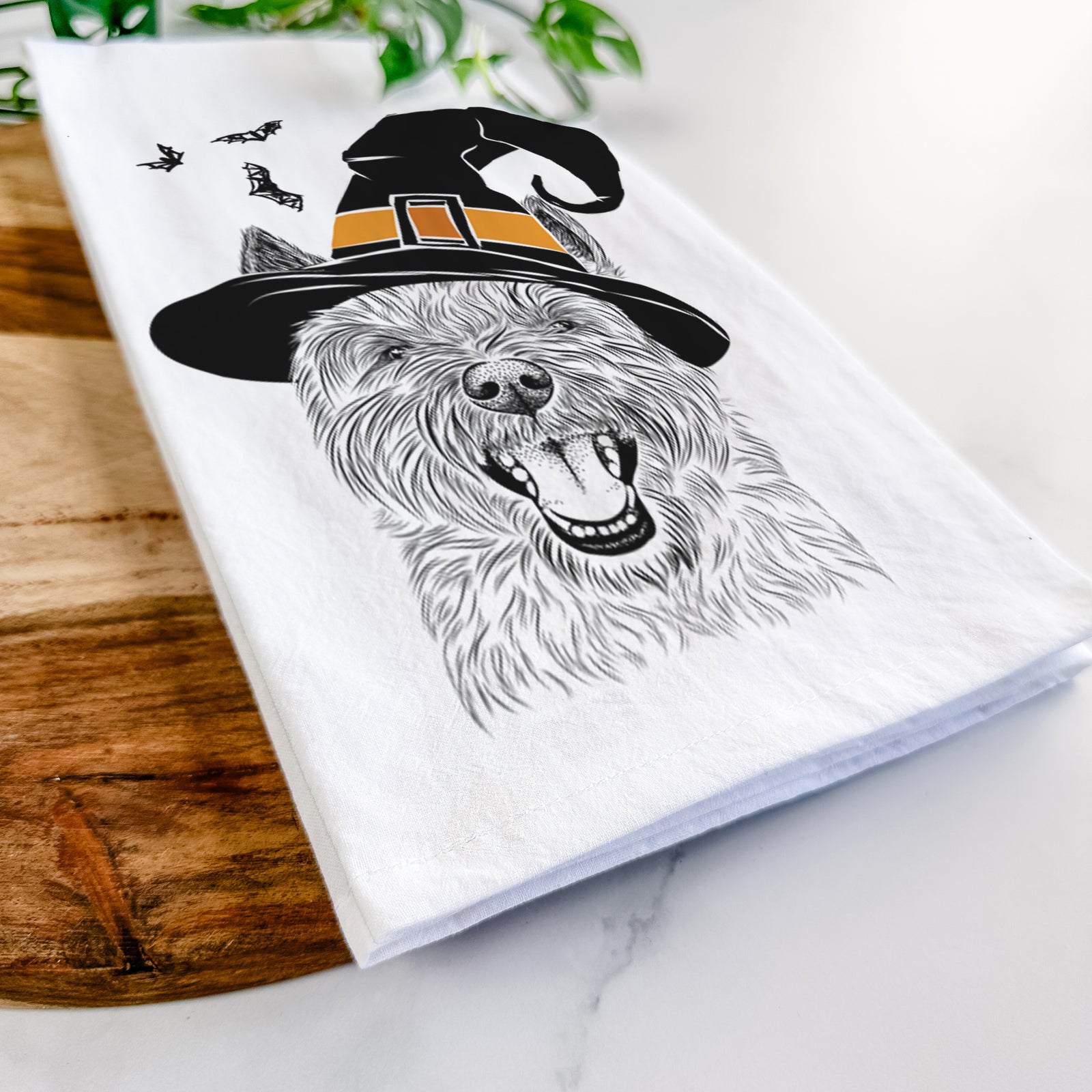 Hand-drawn sketch of Jeff the Cairn Terrier wearing a witch hat on a tea towel