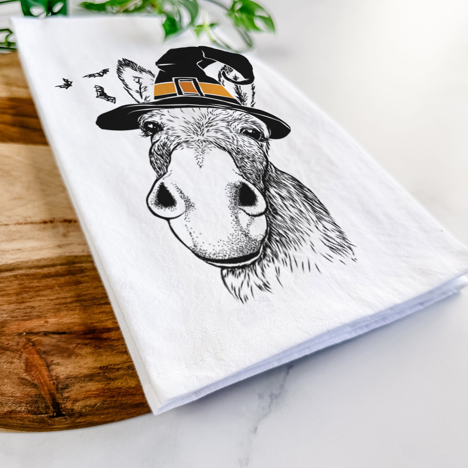 Hand-drawn sketch of Jenny the Donkey wearing a witch hat on a tea towel