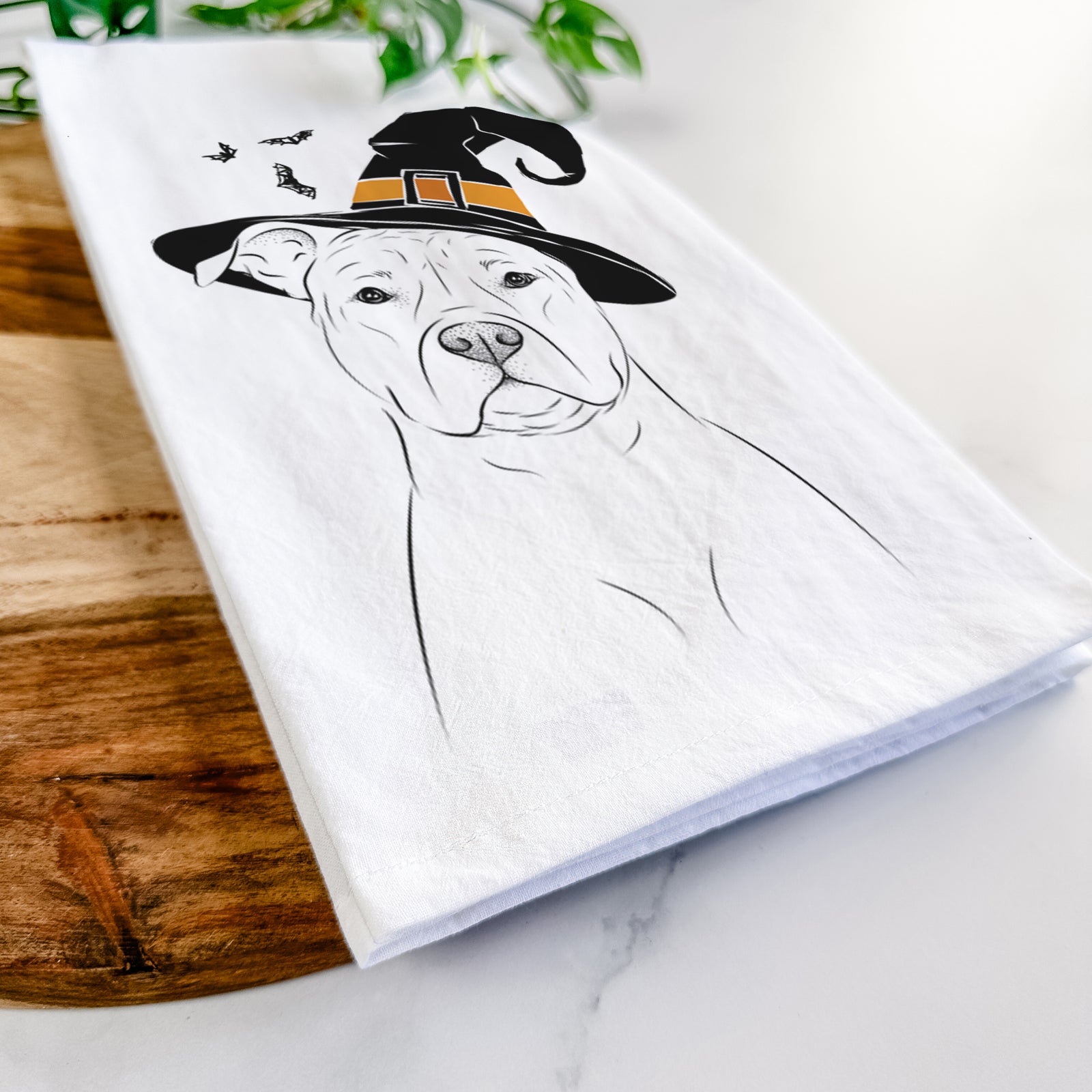 Hand-drawn sketch of Jethro the American Staffordshire Terrier wearing a witch hat on a tea towel