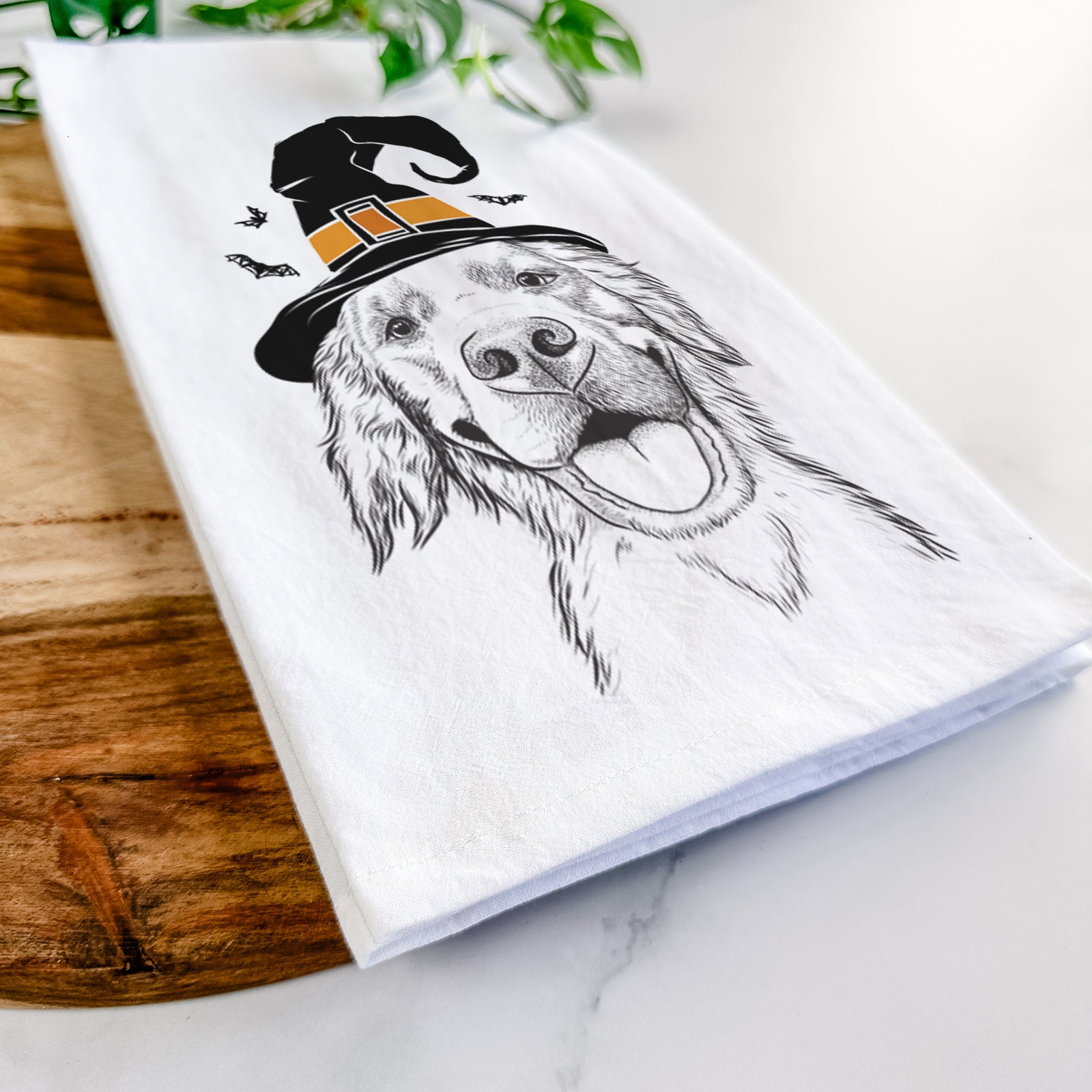 Hand-drawn sketch of Jordy the Golden Retriever wearing a witch hat on a tea towel