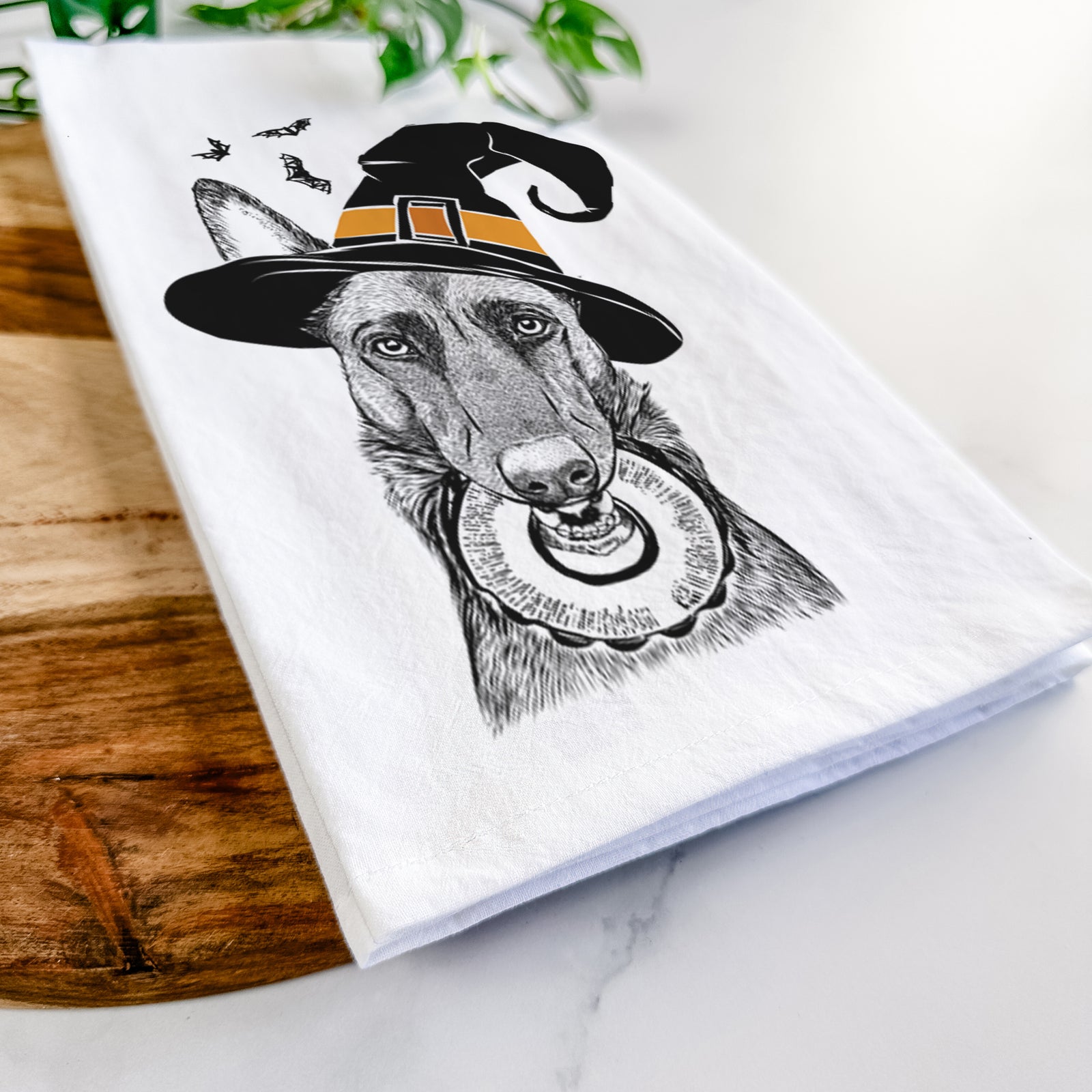 Hand-drawn sketch of Juno the Belgian Malinois wearing a witch hat on a tea towel
