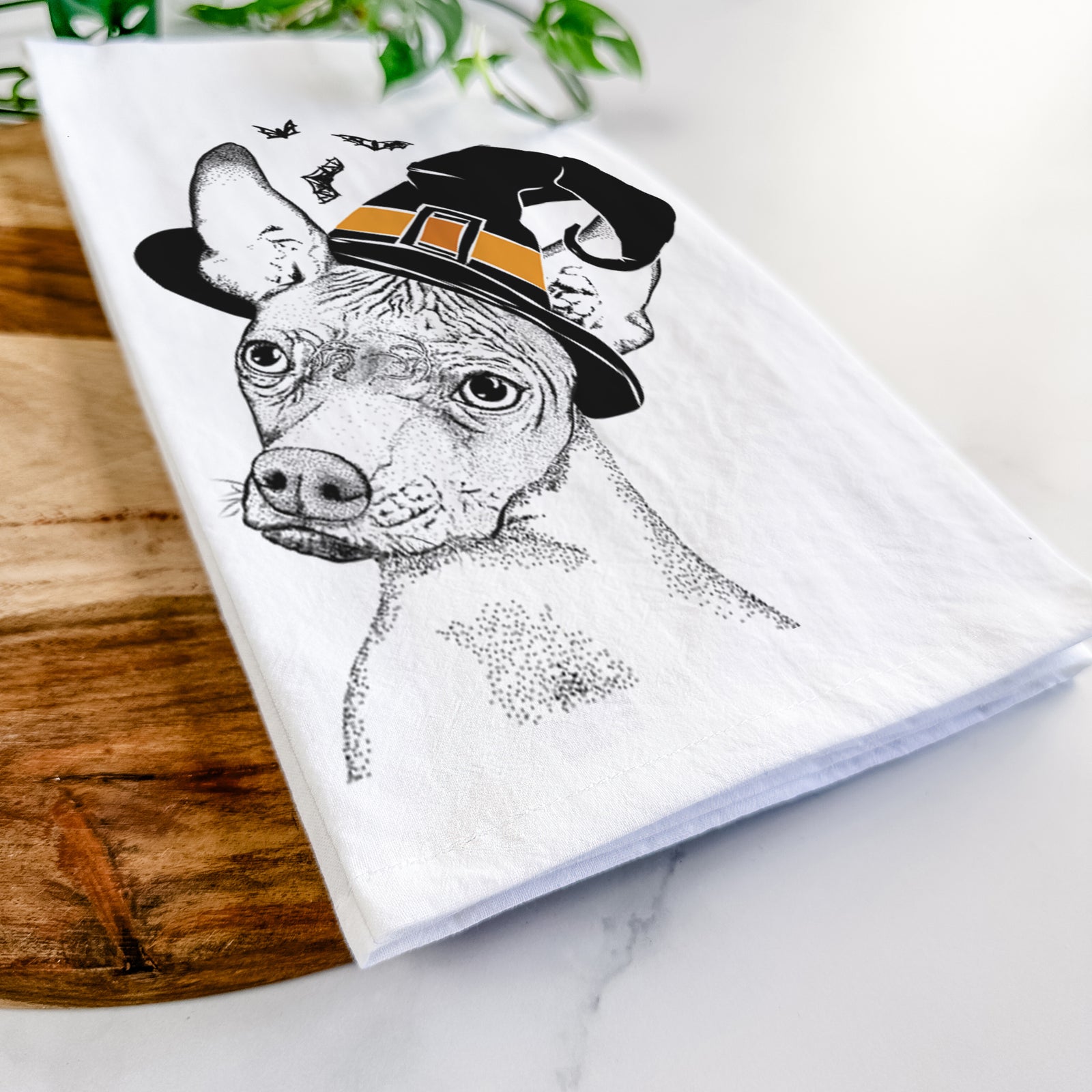 Hand-drawn sketch of Kahlo the Xoloitzcuintli wearing a witch hat on a tea towel