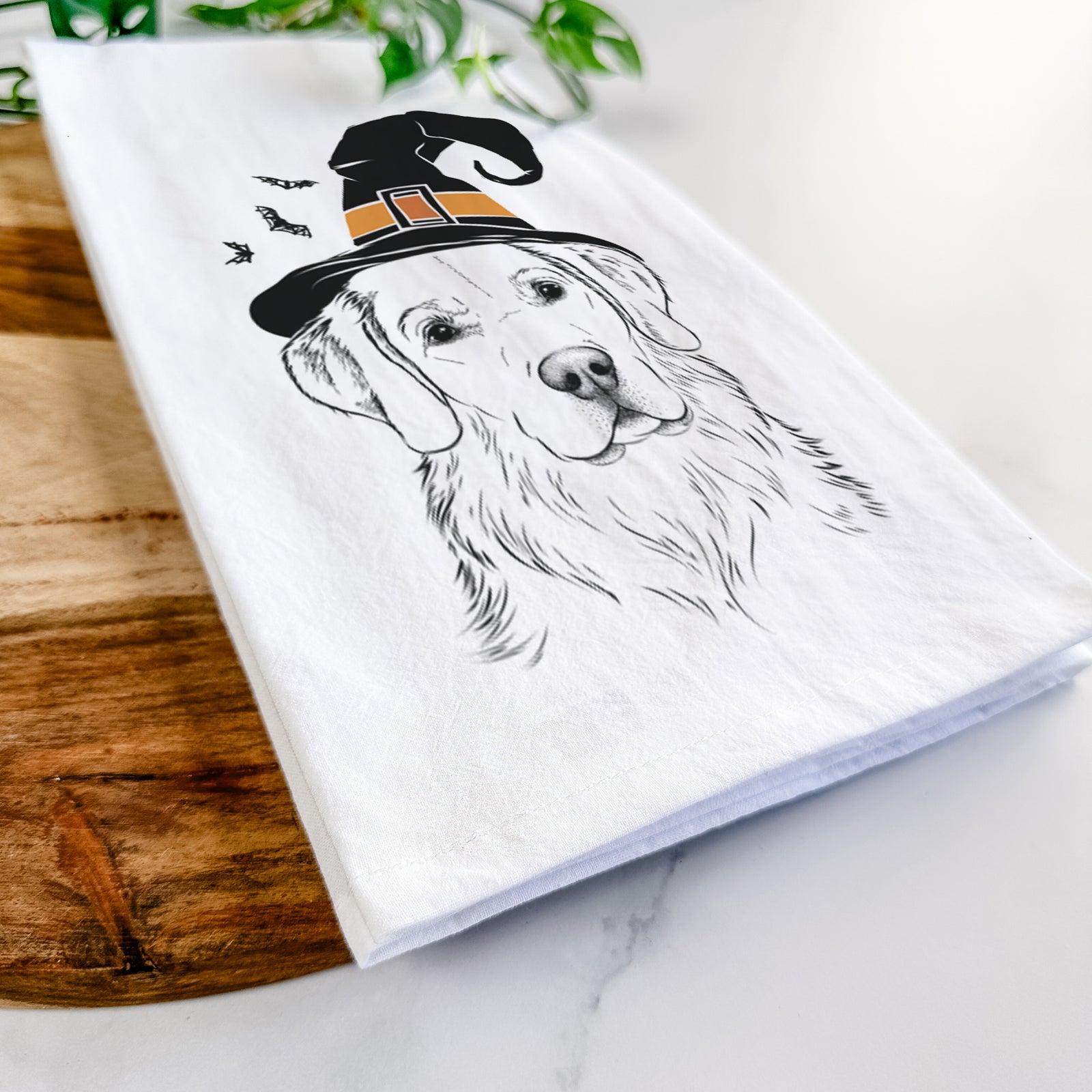 Hand-drawn sketch of Kula the Golden Retriever wearing a witch hat on a tea towel