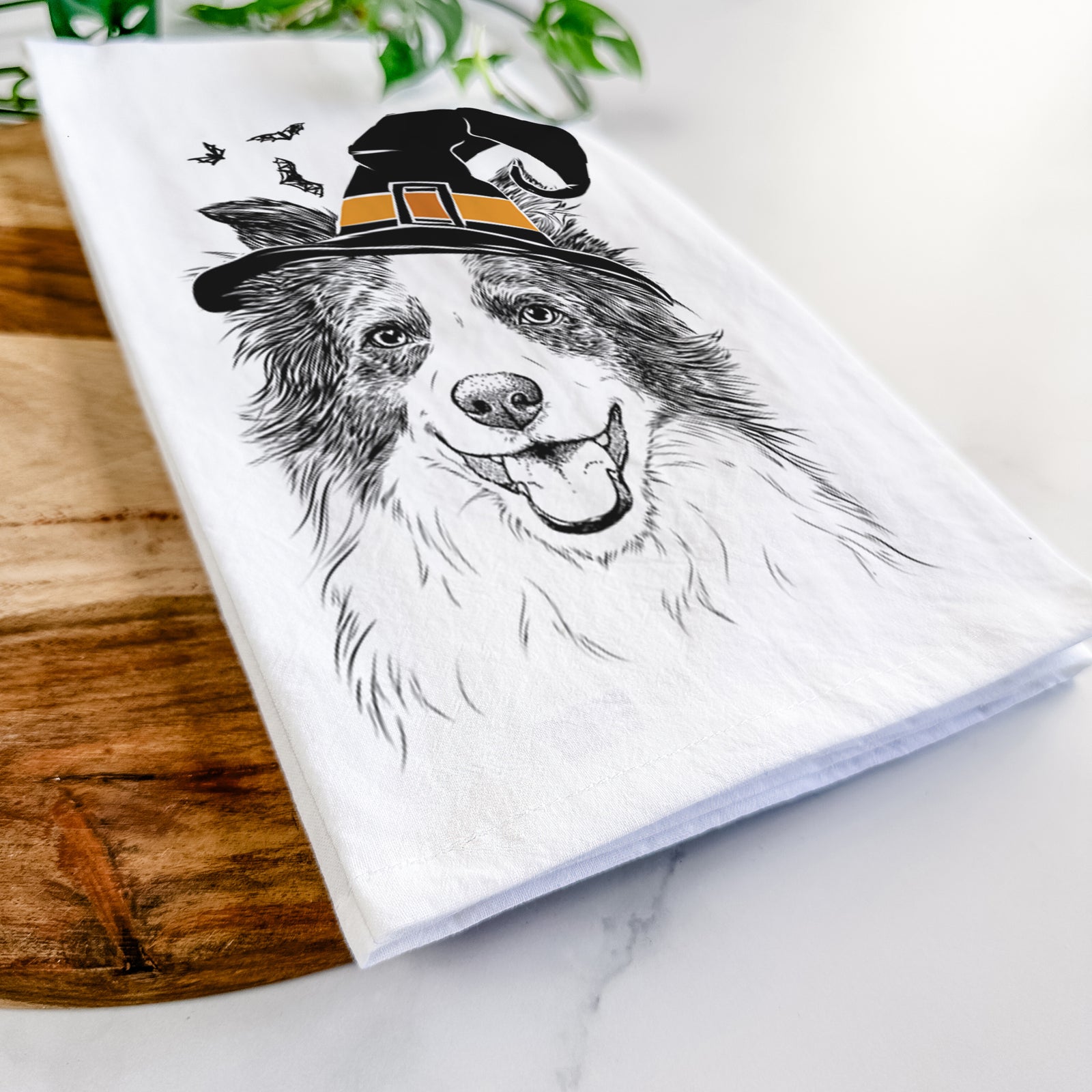 Hand-drawn sketch of Kylee the Border Collie wearing a witch hat on a tea towel