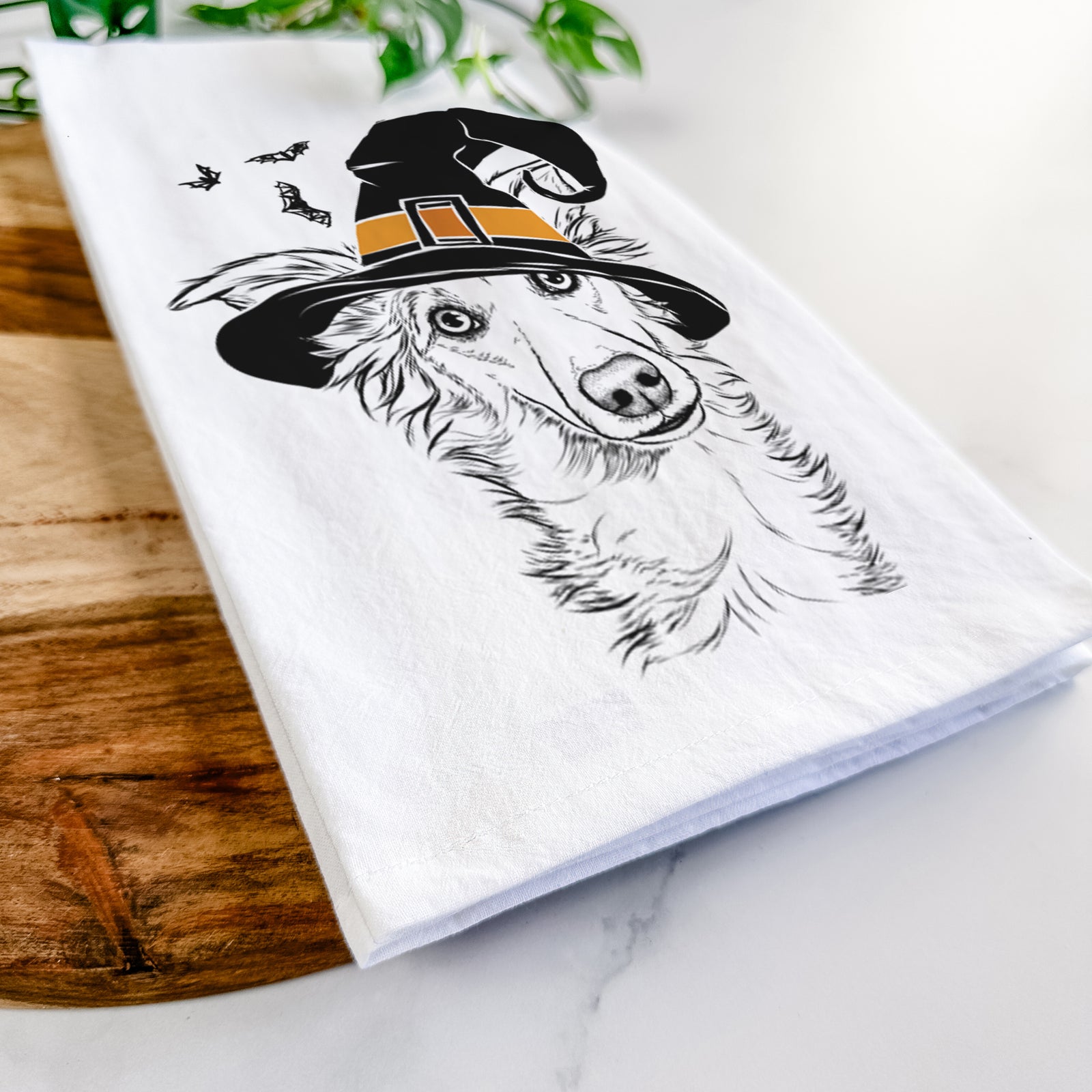 Hand-drawn sketch of Kyu the Windsprite wearing a witch hat on a tea towel
