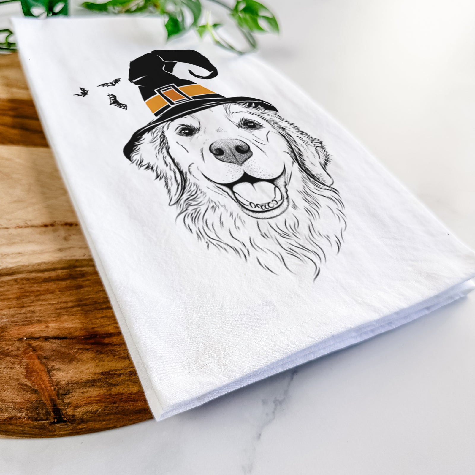 Hand-drawn sketch of Legend the Golden Retriever wearing a witch hat on a tea towel