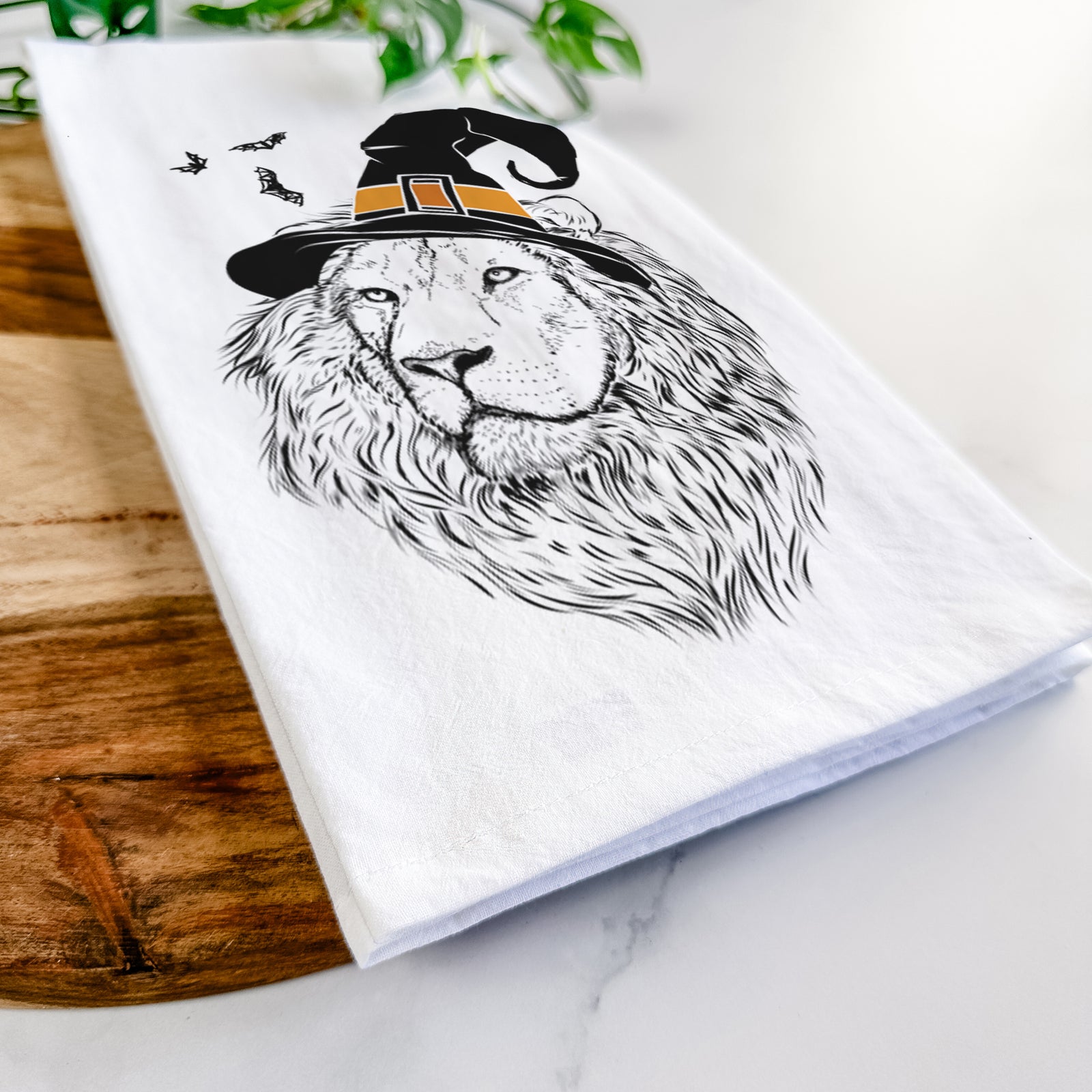 Hand-drawn sketch of Lenny the Lion wearing a witch hat on a tea towel