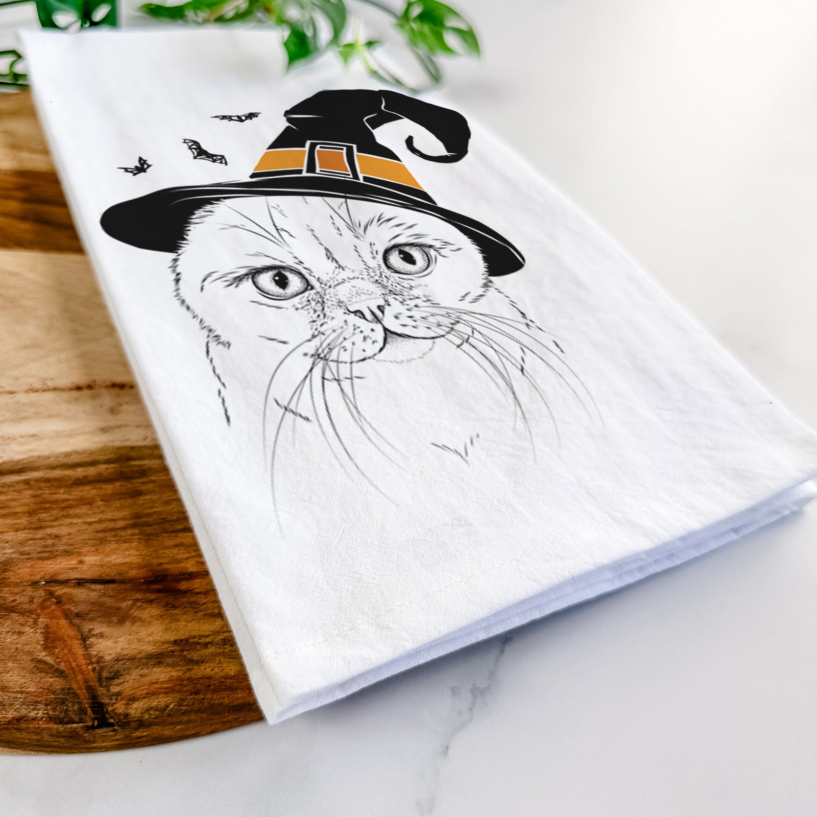 Hand-drawn sketch of Lina the Exotic Fold Cat wearing a witch hat on a tea towel