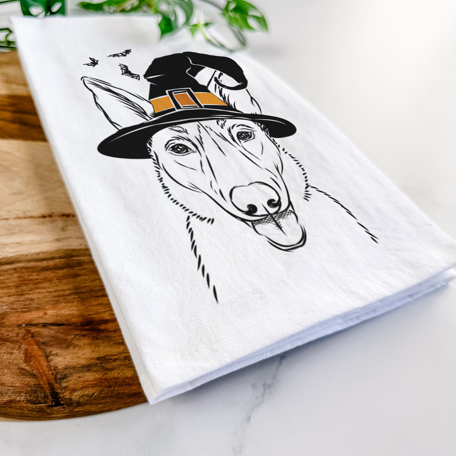 Hand-drawn sketch of Lyric the Belgian Malinois wearing a witch hat on a tea towel