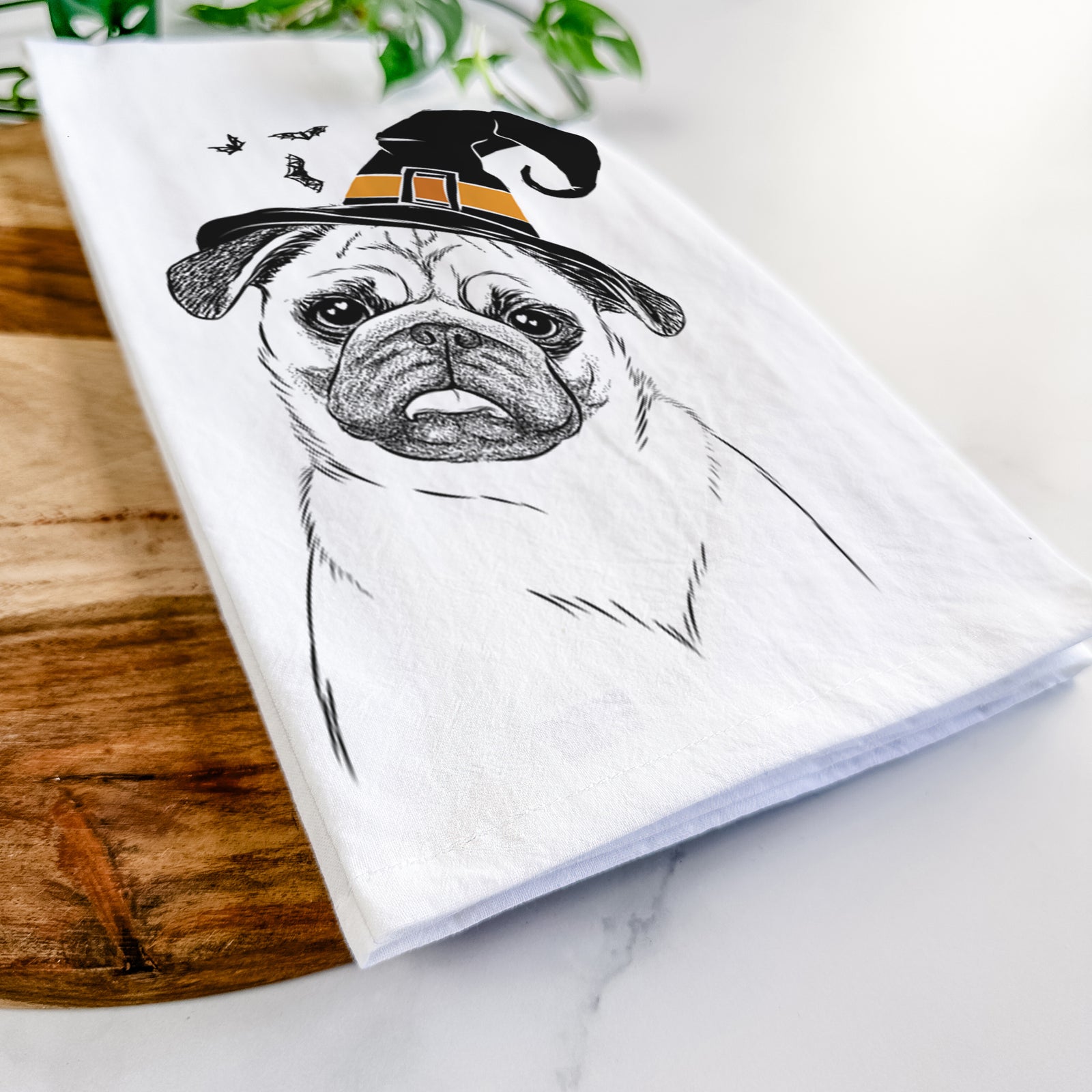 Hand-drawn sketch of Macy the Pug wearing a witch hat on a tea towel