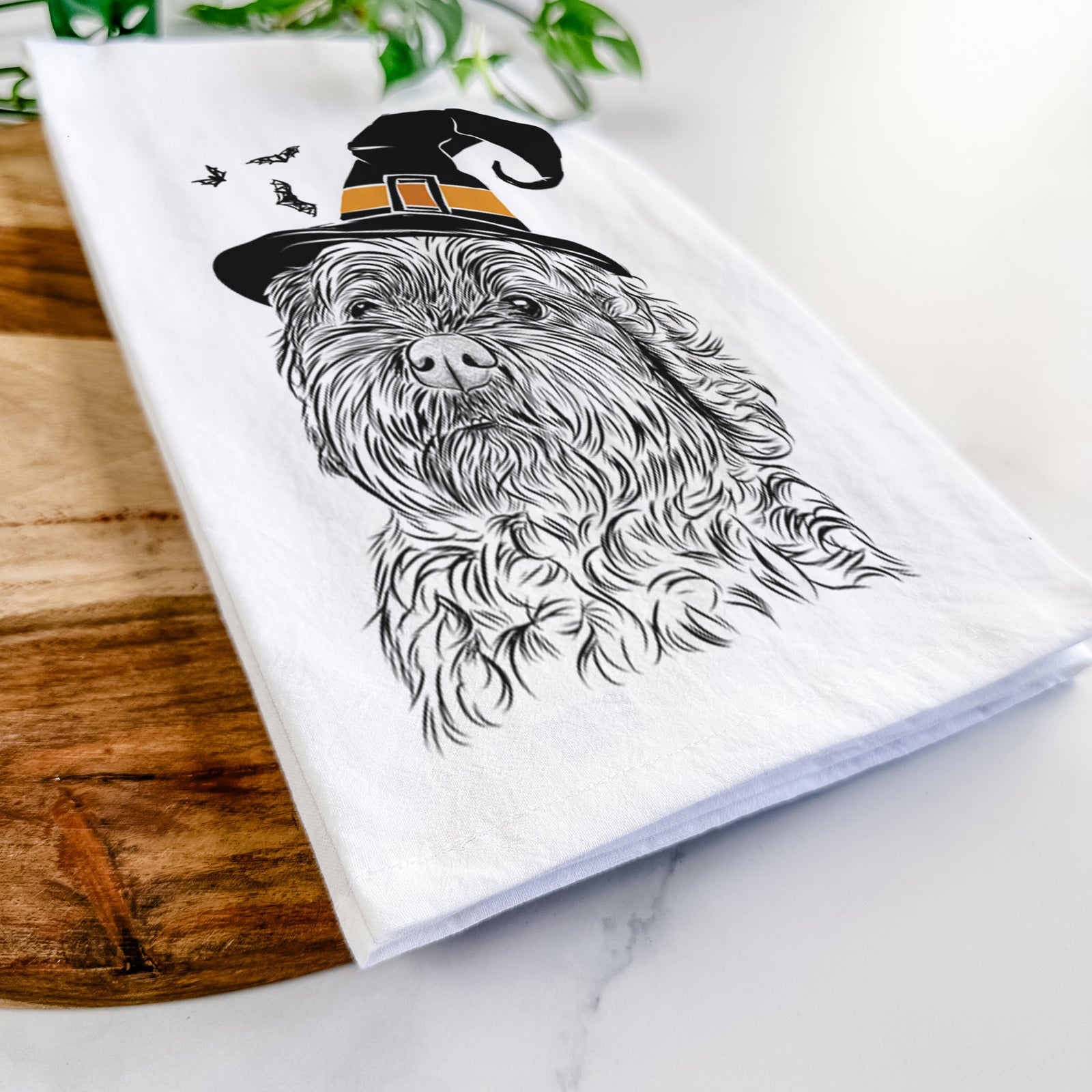 Hand-drawn sketch of Maggie Girl the Cockapoo wearing a witch hat on a tea towel