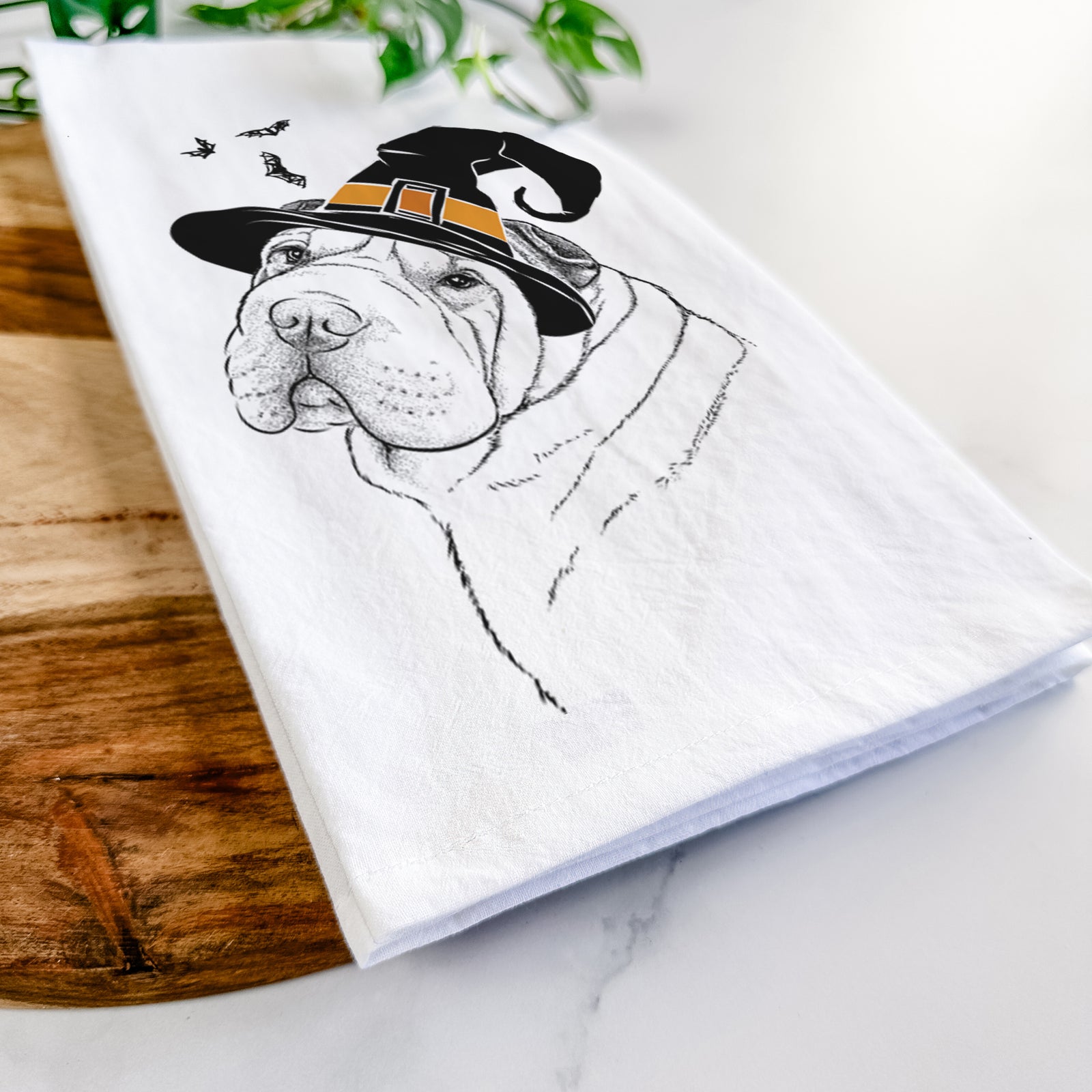 Hand-drawn sketch of Maximus the Shar Pei wearing a witch hat on a tea towel